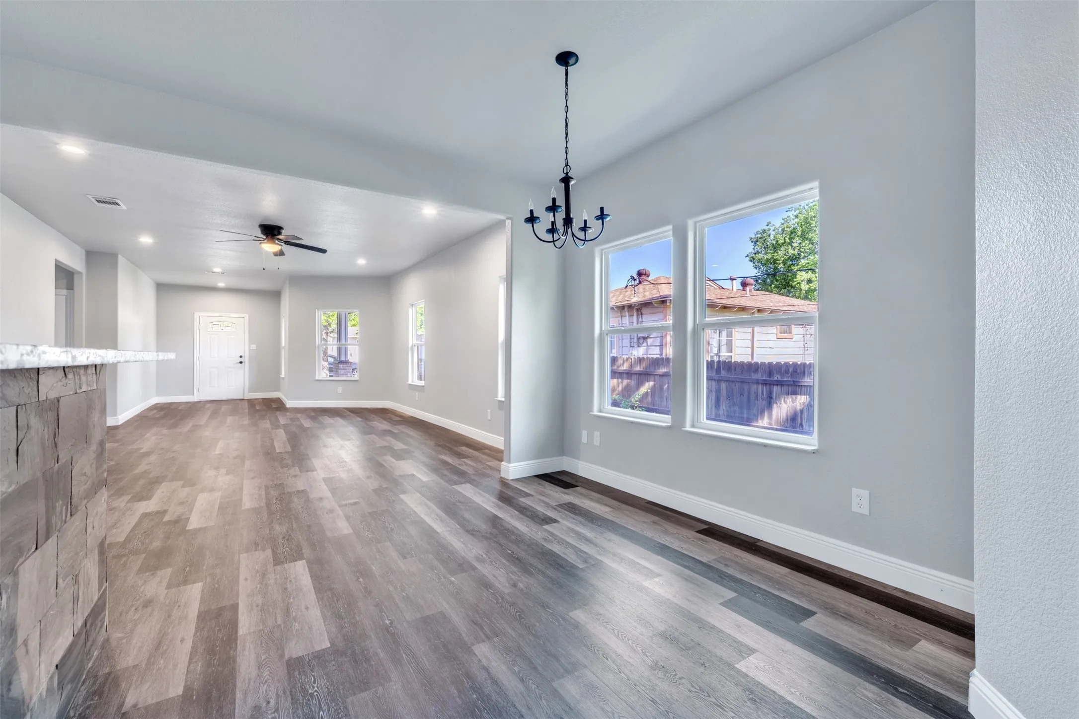 Open-concept interior featuring wood-finish flooring, recessed lighting, and a chandelier fixture