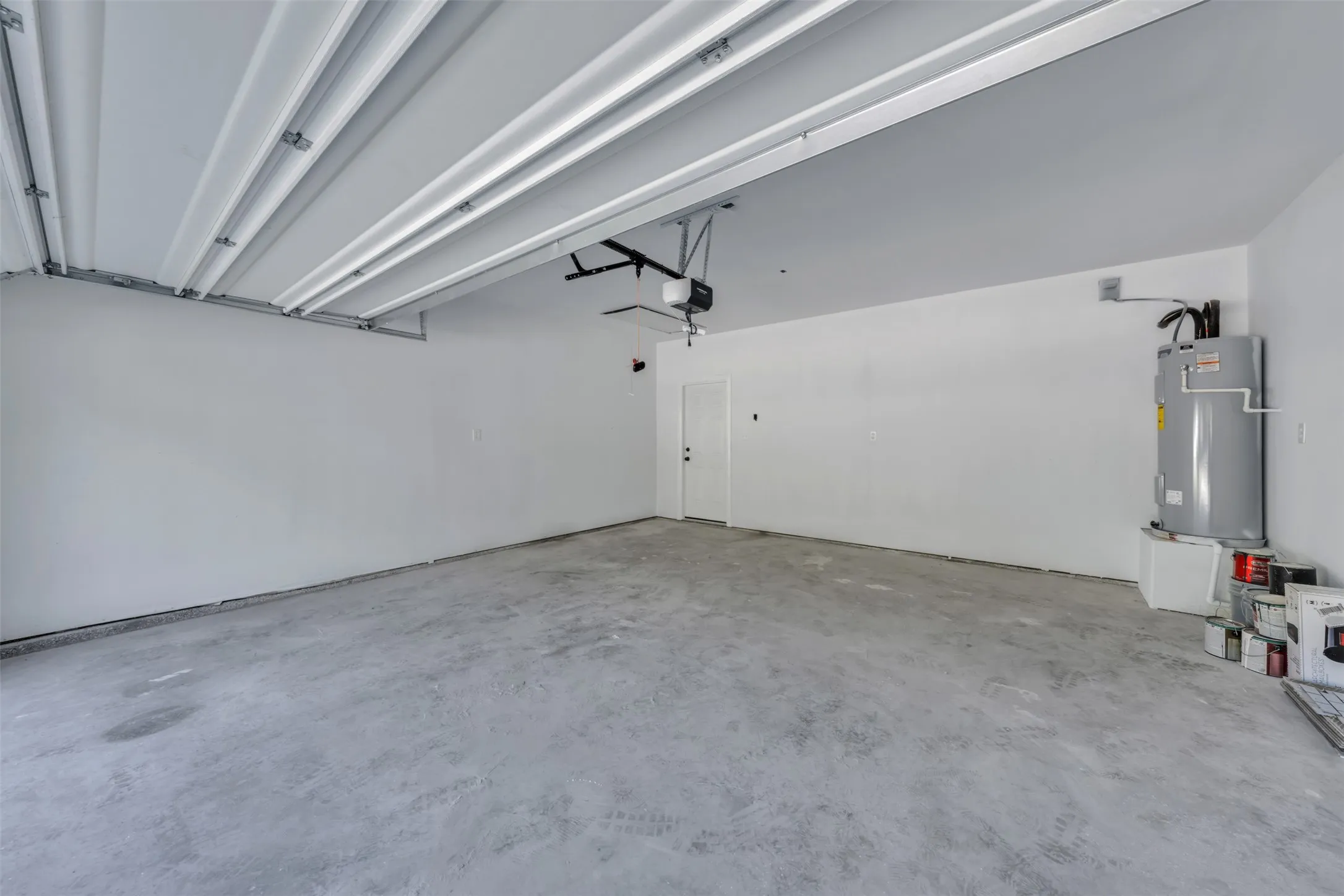 Spacious garage featuring concrete flooring, painted walls, and an automatic garage door opener
