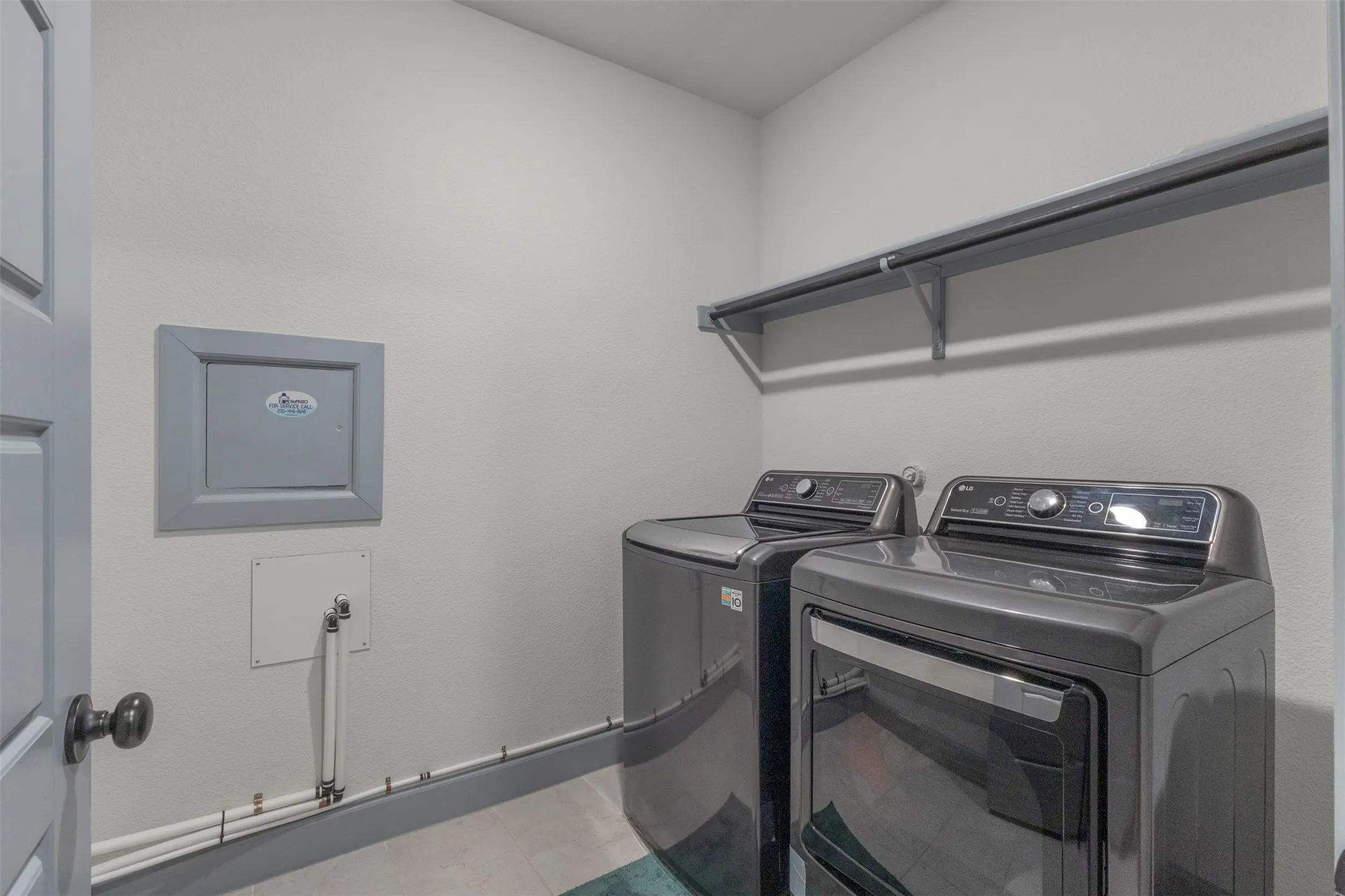 Dedicated laundry area featuring a wall-mounted shelving unit