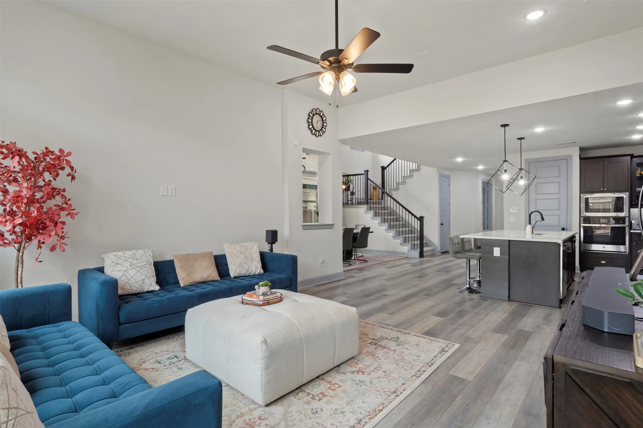 Living area featuring lLVP flooring, a contemporary ceiling fan, and recessed lighting