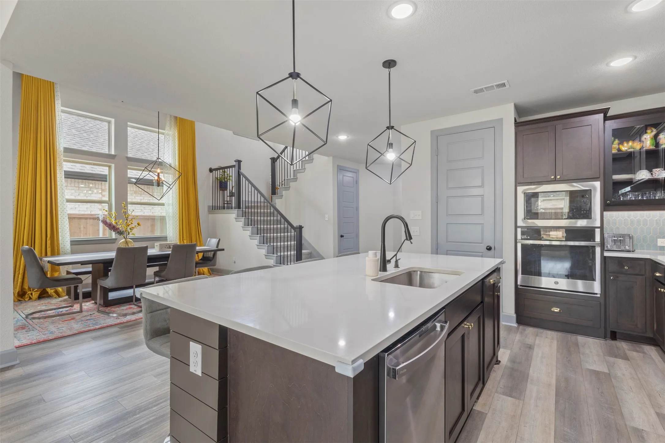 Kitchen island featuring a stainless steel sink, gooseneck faucet, and integrated dishwasher