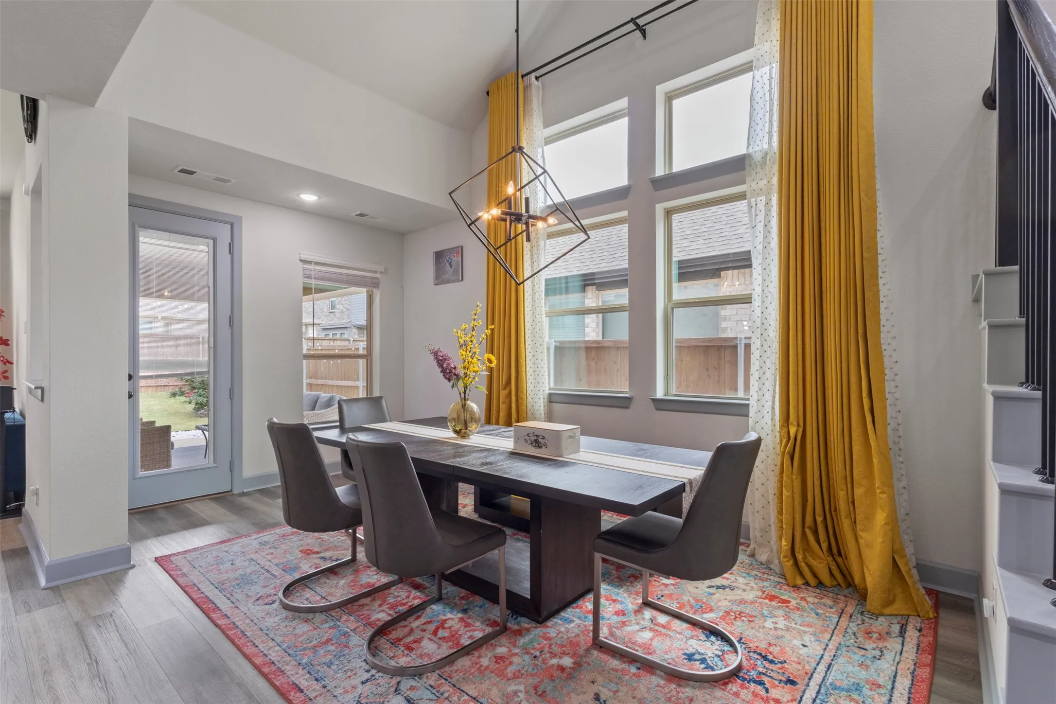 Dining area featuring LVP flooring, a contemporary chandelier, and a wall of windows