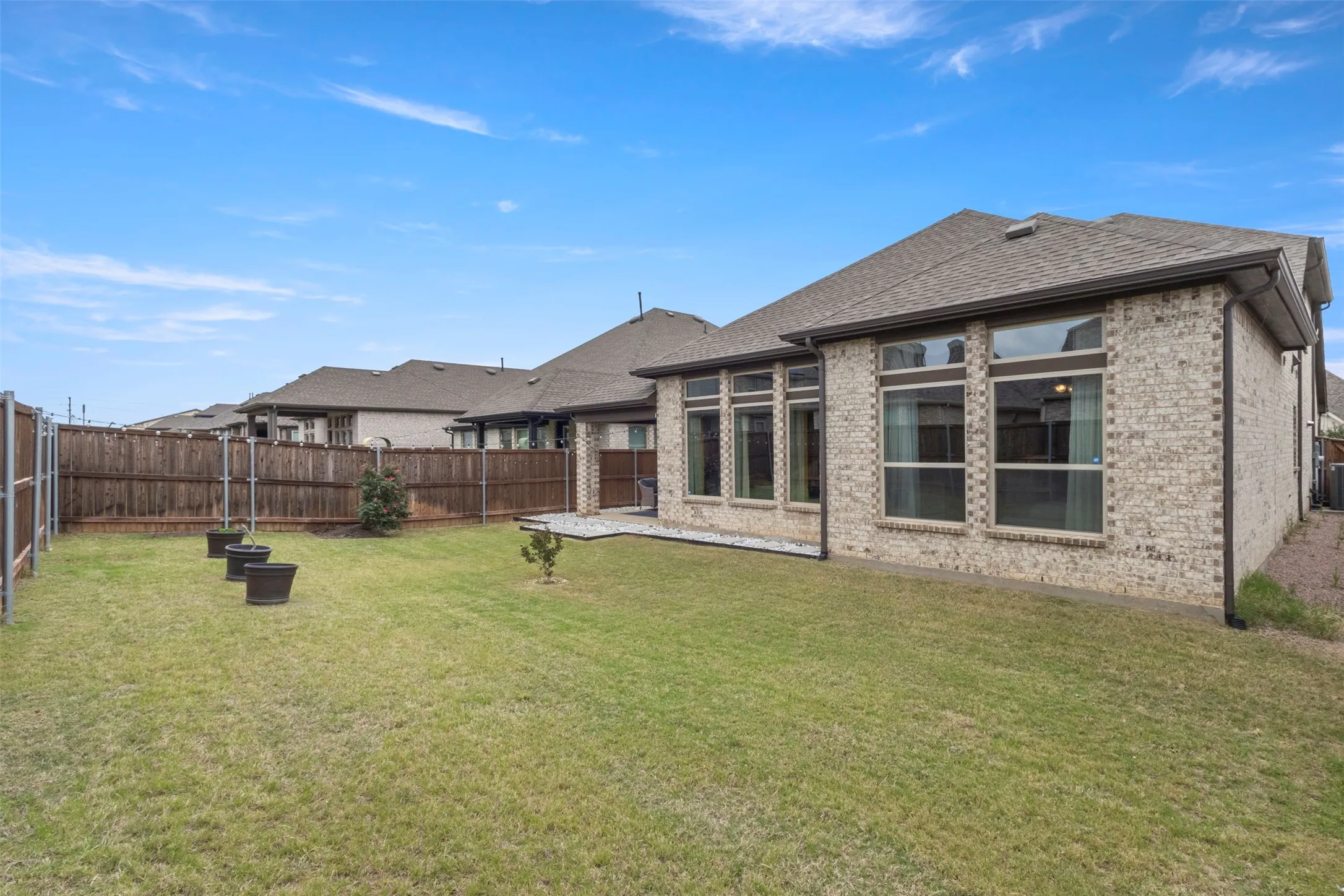 Expansive green lawn with a privacy fence