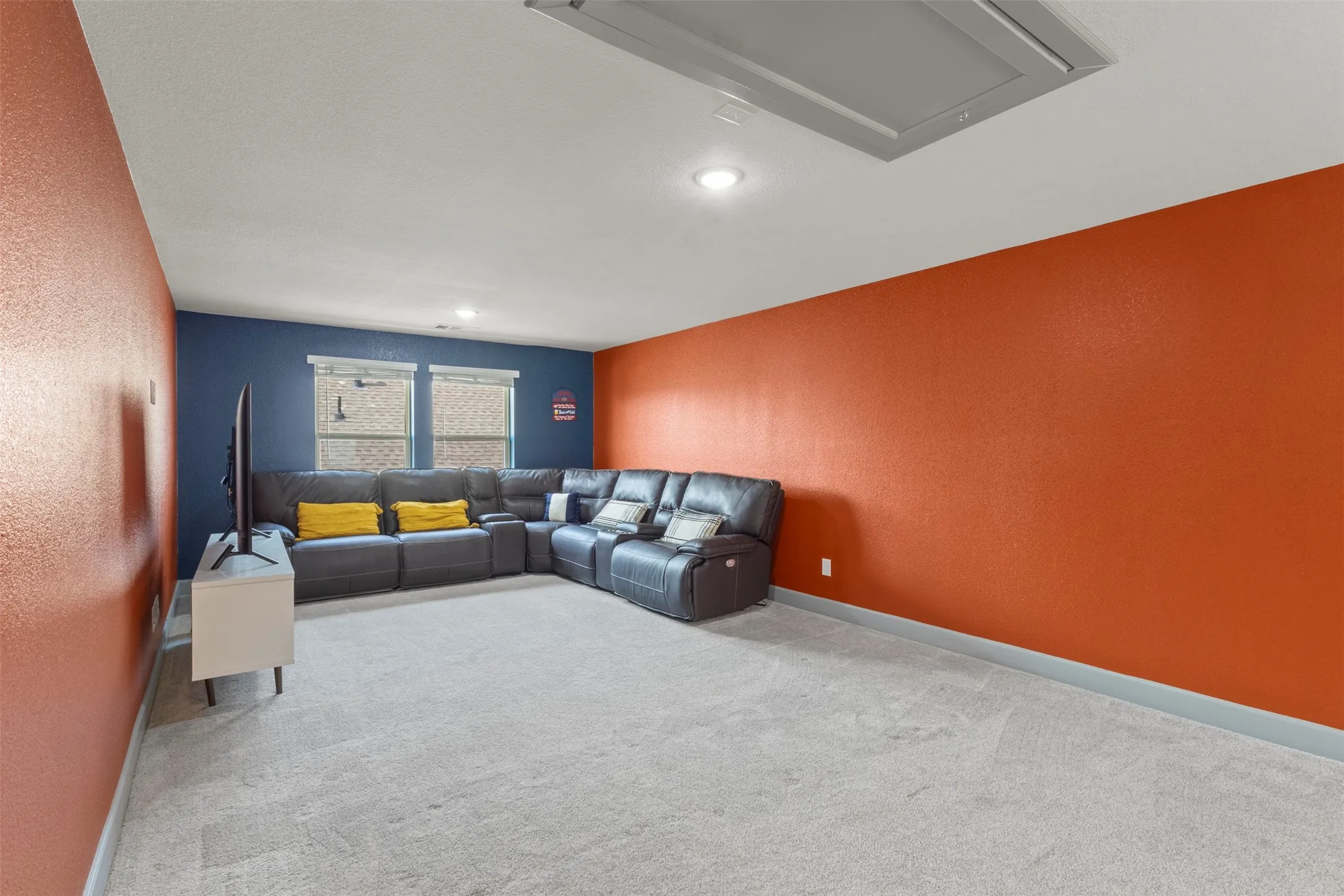 Spacious room featuring light-colored carpeting, recessed lighting, and a neutral ceiling