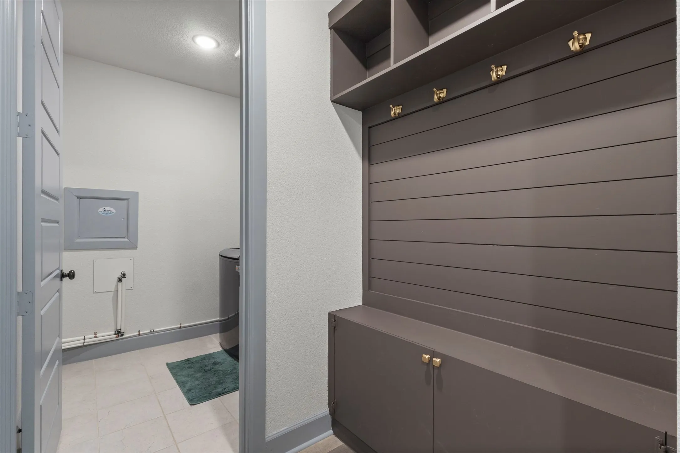 Entryway featuring a custom built-in mudroom bench with integrated storage and shelving