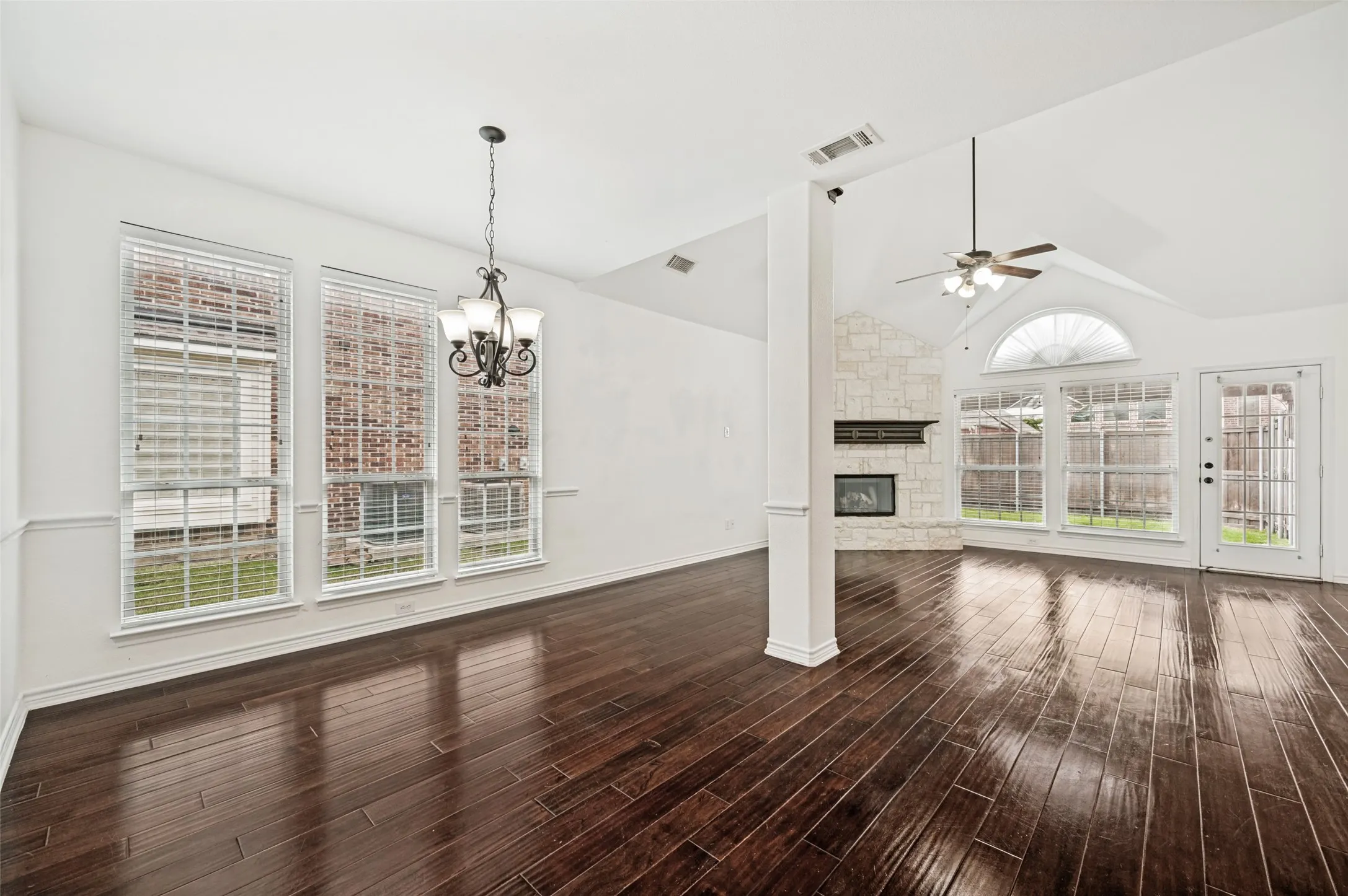 Vaulted ceilings accentuating a stone-faced fireplace and dark wood-finish flooring