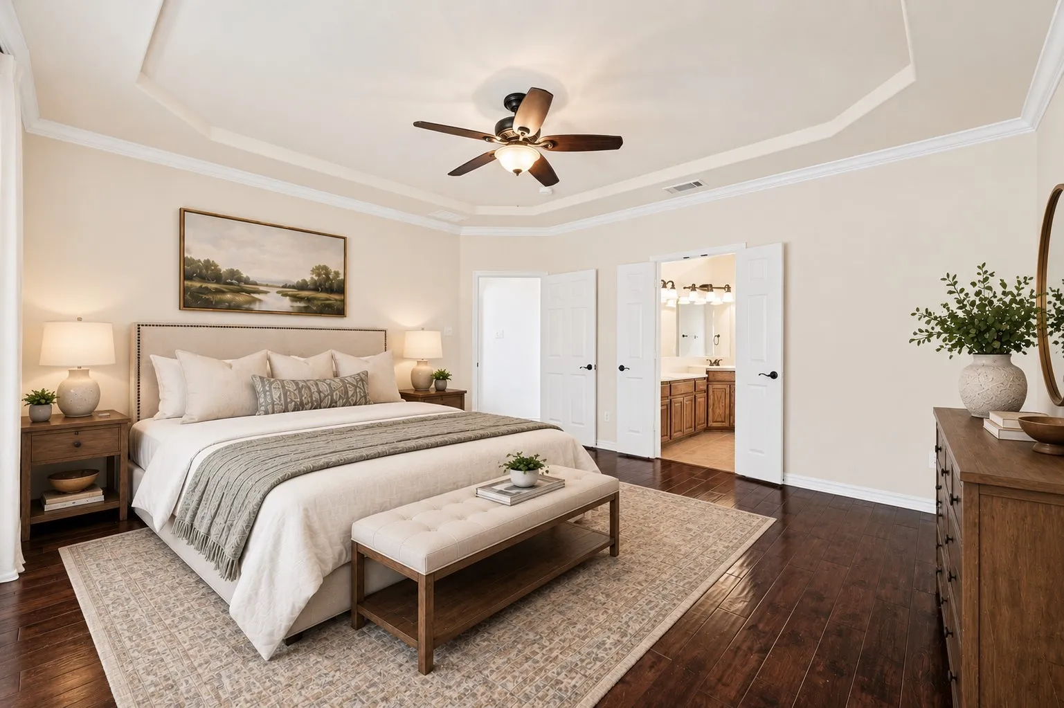 Tray ceiling with crown molding, wood-finish flooring, and double French doors; virtually staged