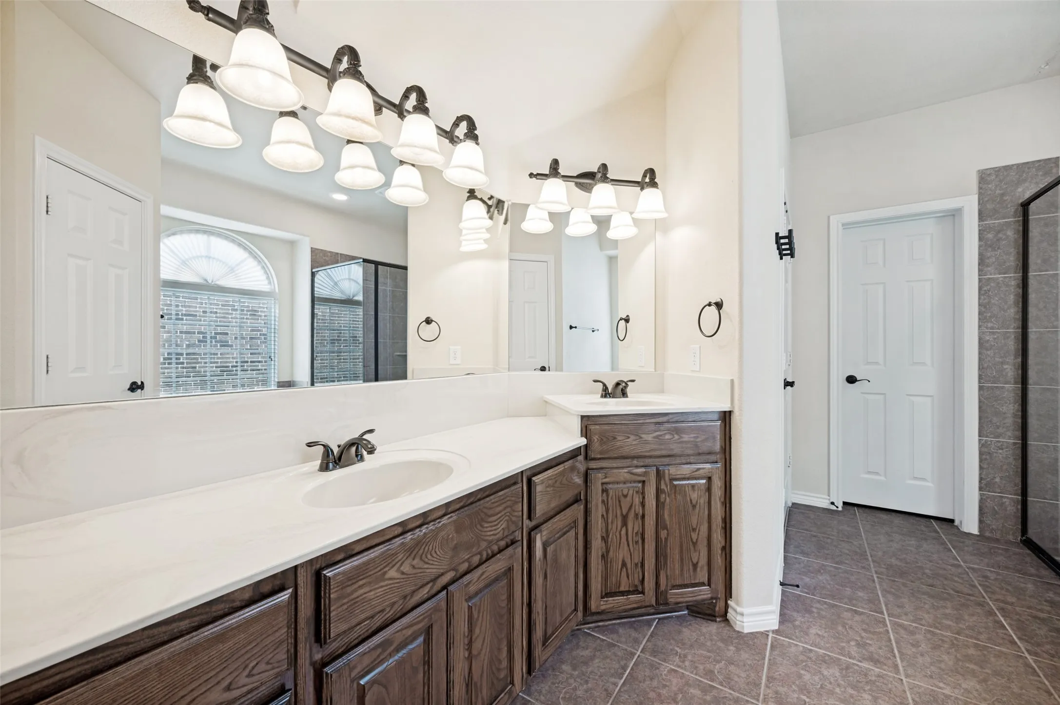 Dual vanities with white countertops and dark wood-finish cabinetry