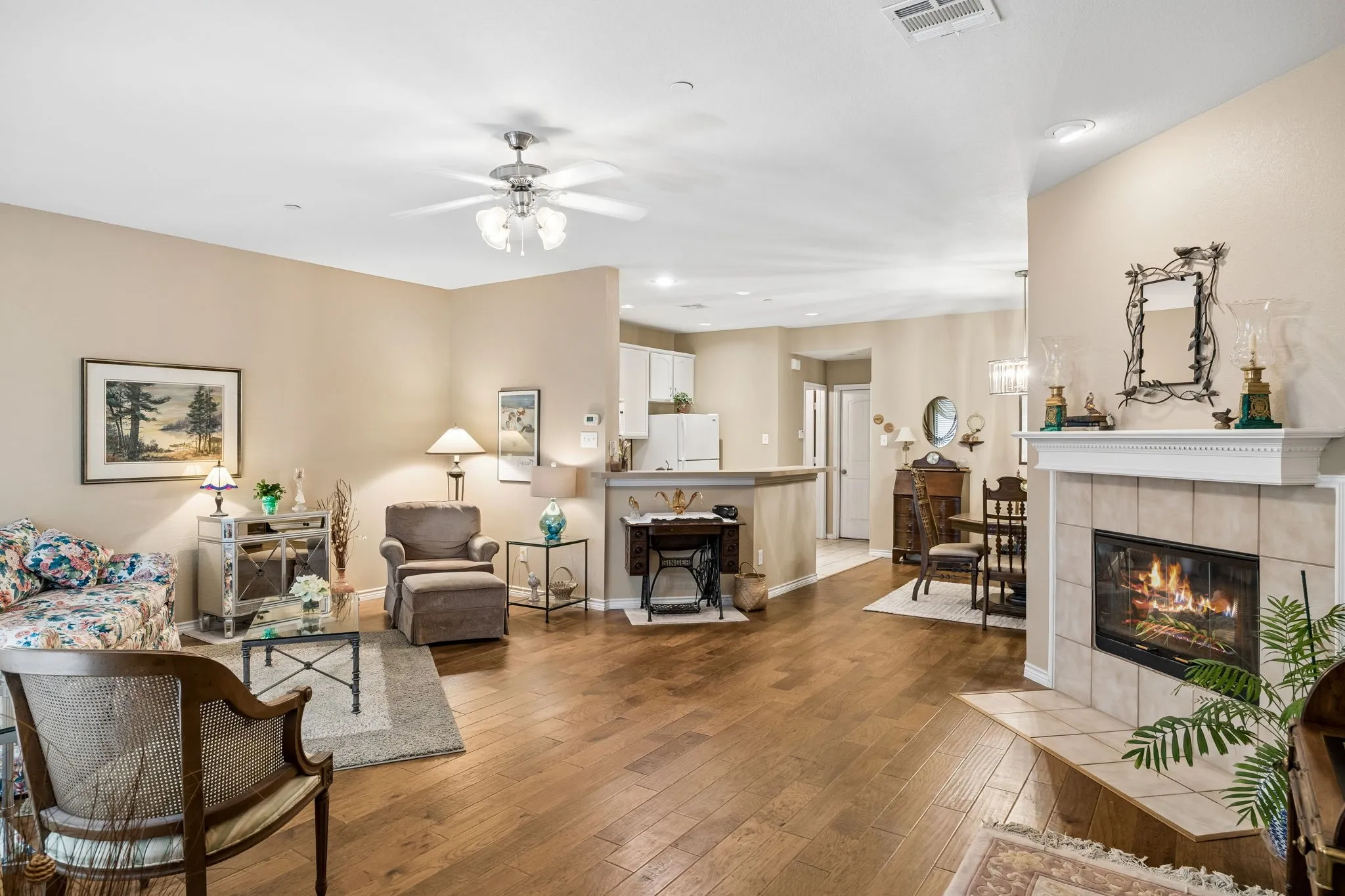 The open living area featuring rich Engineered Hardwood Flooring, soft neutral tones, and a stylish gas fireplace with electric starter!