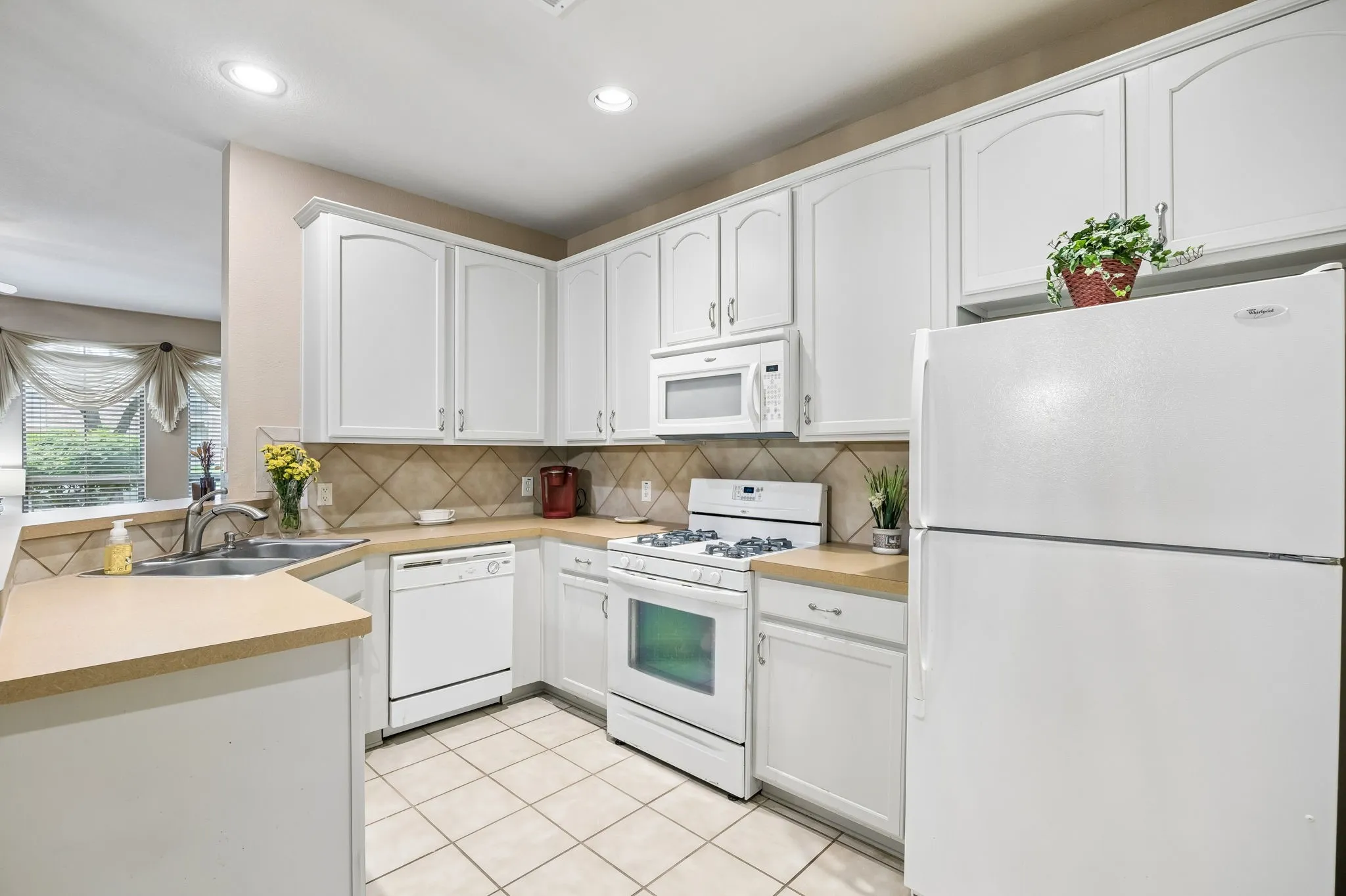 Wow!  Check out all the storage, stylish white appliances and SS sink with lovely backsplash!