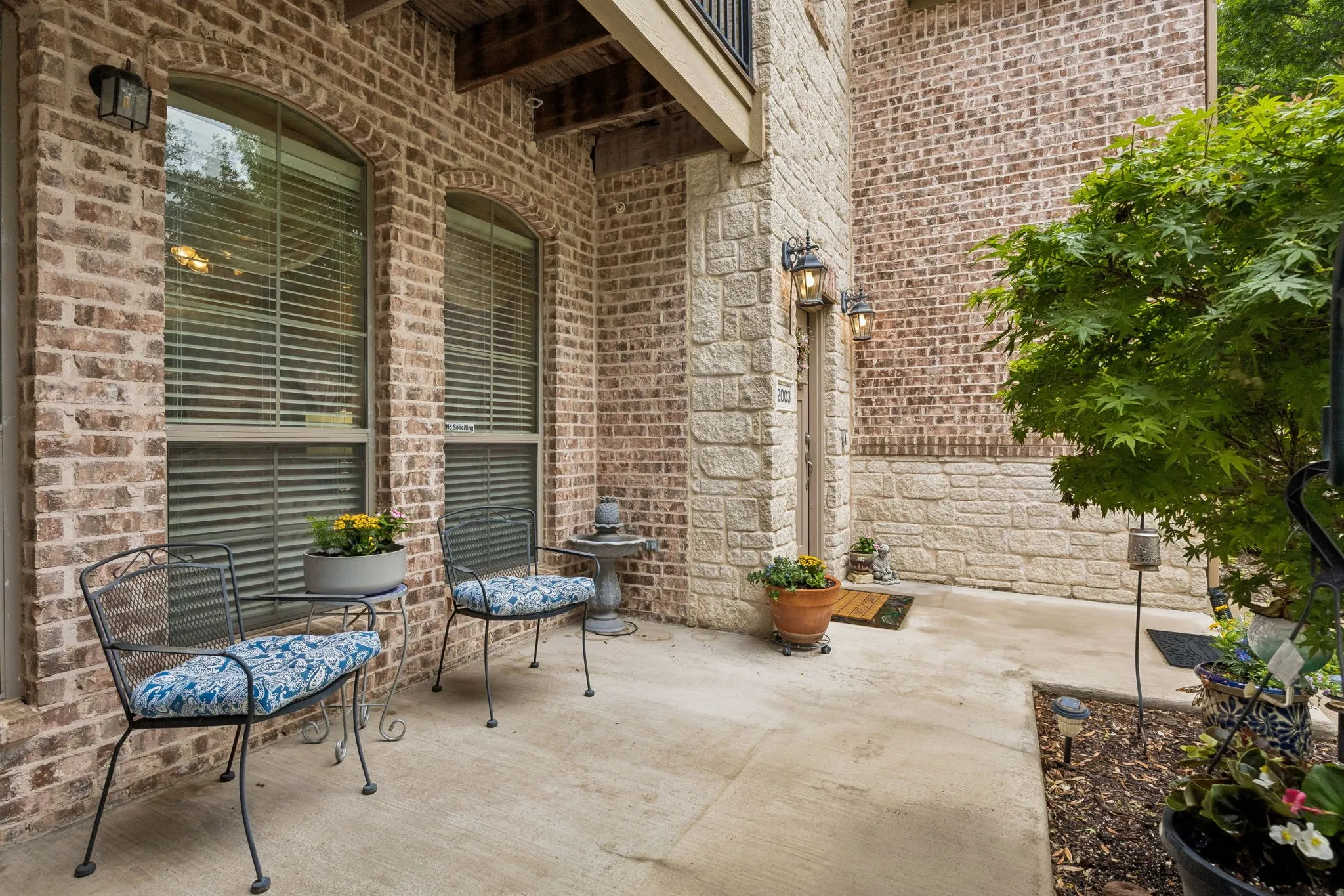 The spacious front patio creates a serene outdoor setting with room for seating and decorative planters.