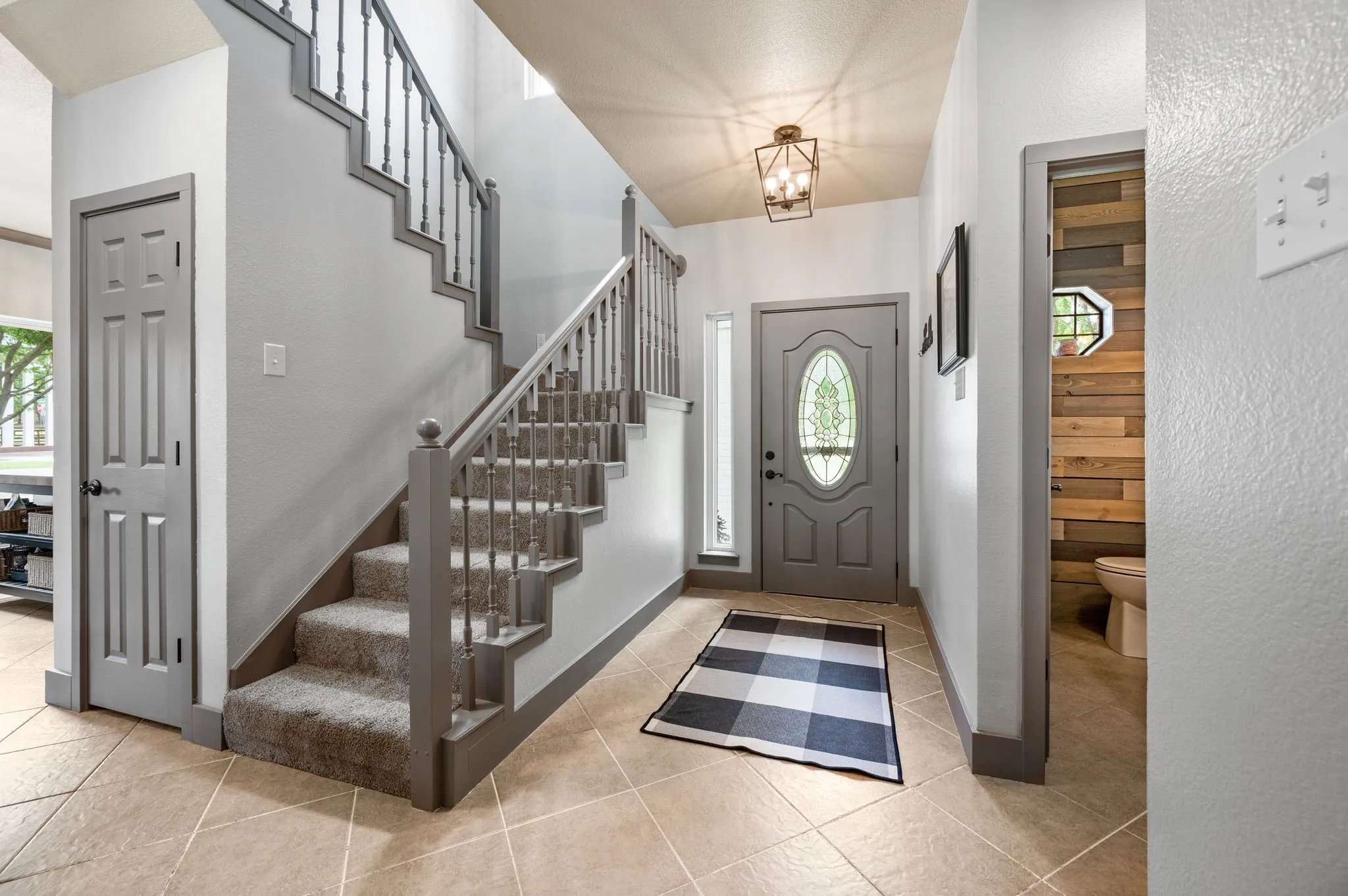 Tiled entry. Fresh paint. Updated lighting. The closet next to the stairs is more than just a coat closet. It's extra deep, wrapping all the way back for excellent storage space.