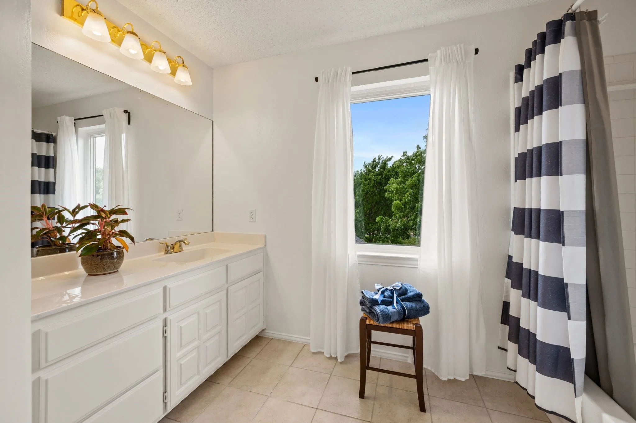 Upstairs en-suite bath includes a tile surround bath, large vanity and tile floors.