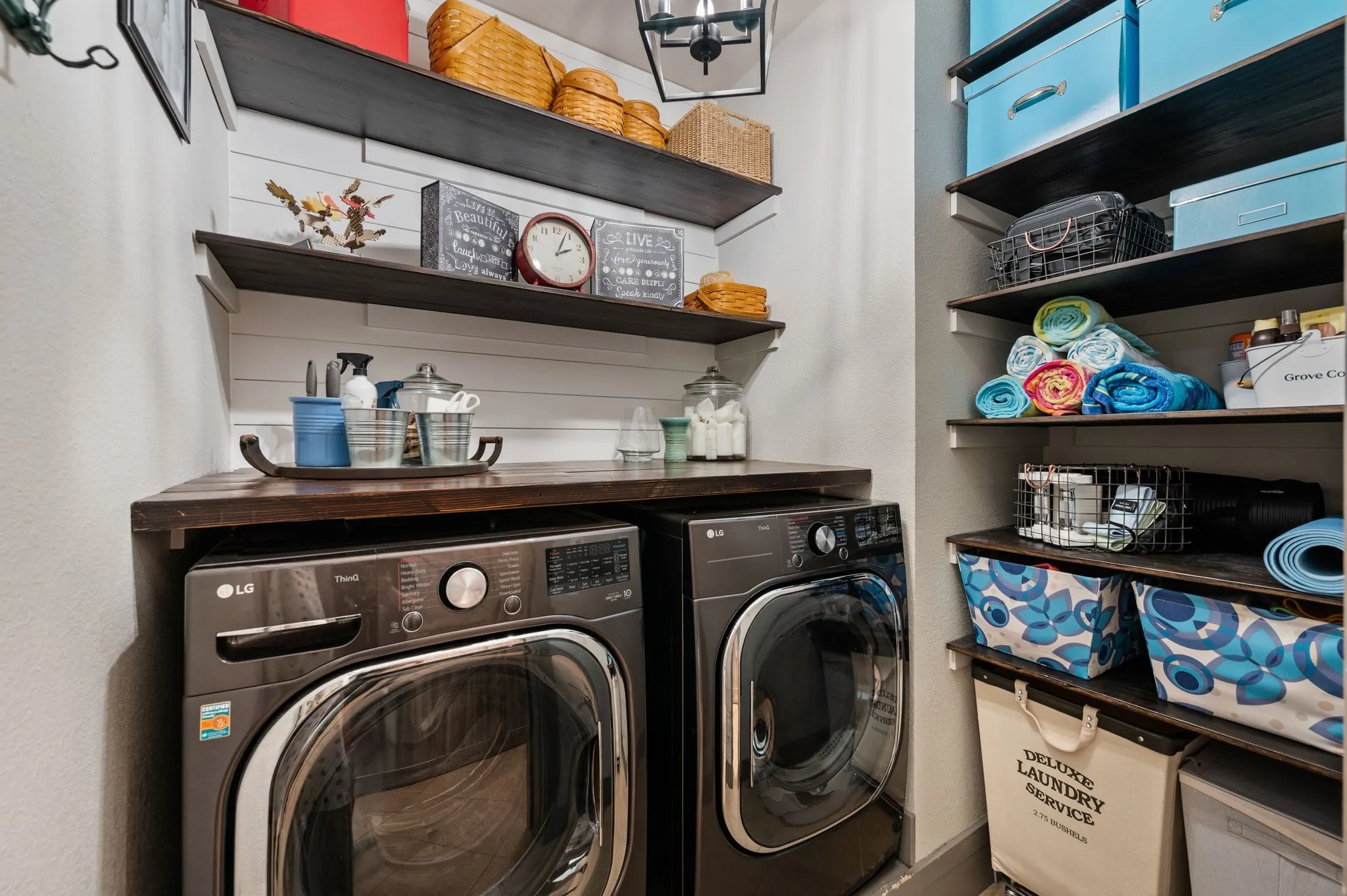 If you need a little help with organization, this laundry room will do the trick. A shiplap wall, repurposed wood counter, farmhouse lighting and a space saving barn door give this practical room style.