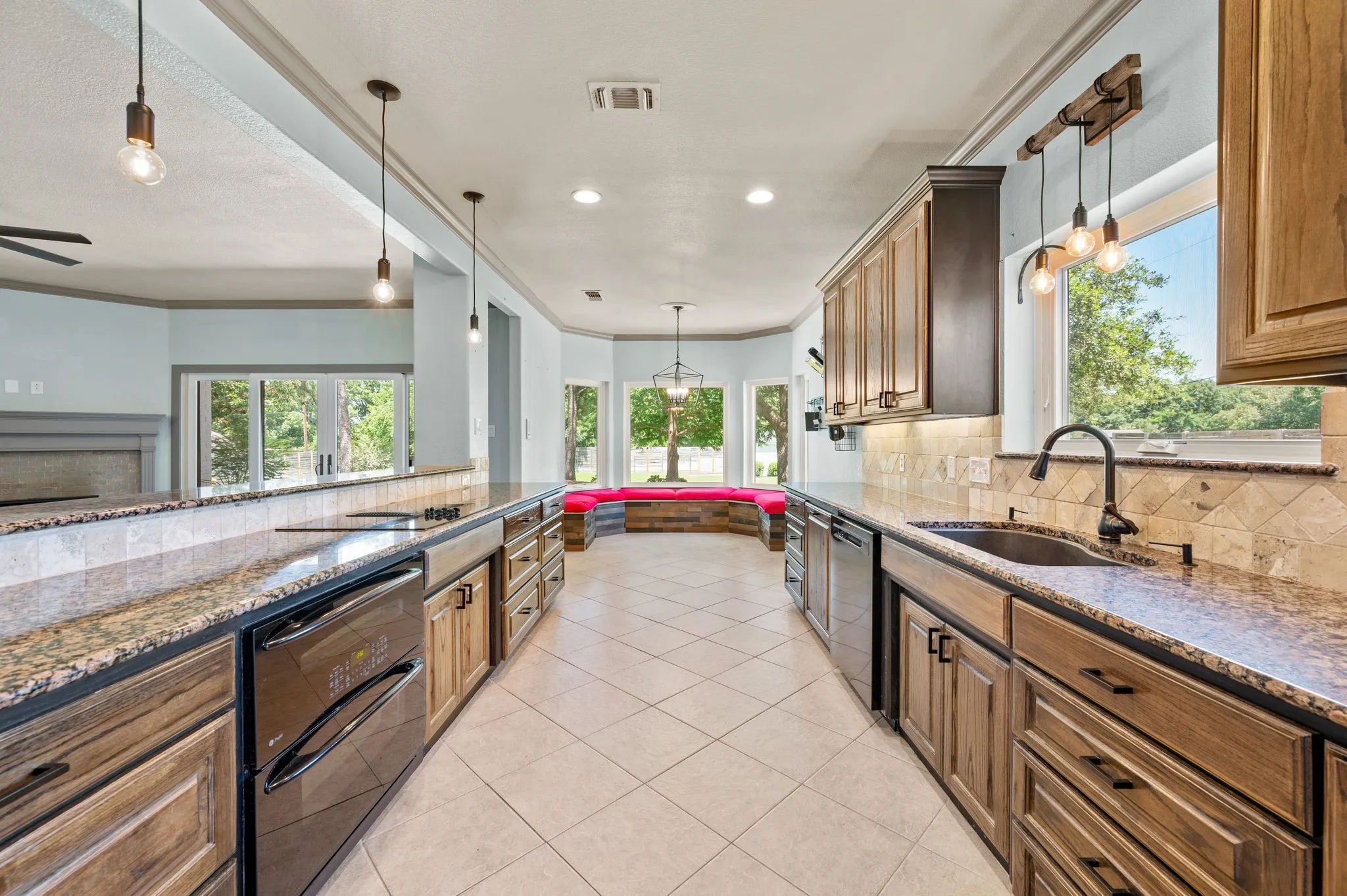This beautiful kitchen provides ample counter and cabinet space. Granite counters. Modern lighting. Double oven. Undermount farm sink with window view. New dishwasher in 2025. Tons of cabinet space for storage and a bay window with storage bench seating.