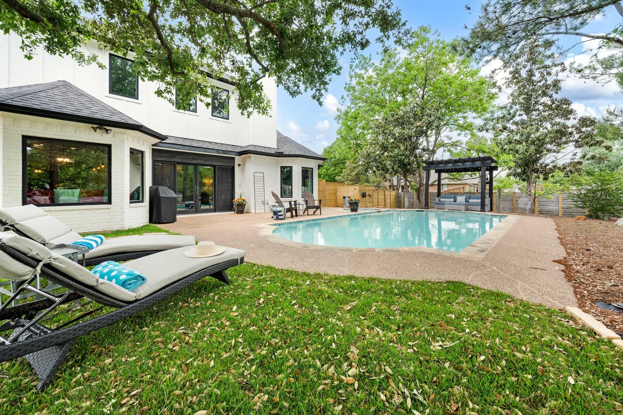 An arbor covered seating area, shade trees and lush grass stretch your summer days with summertime fun.