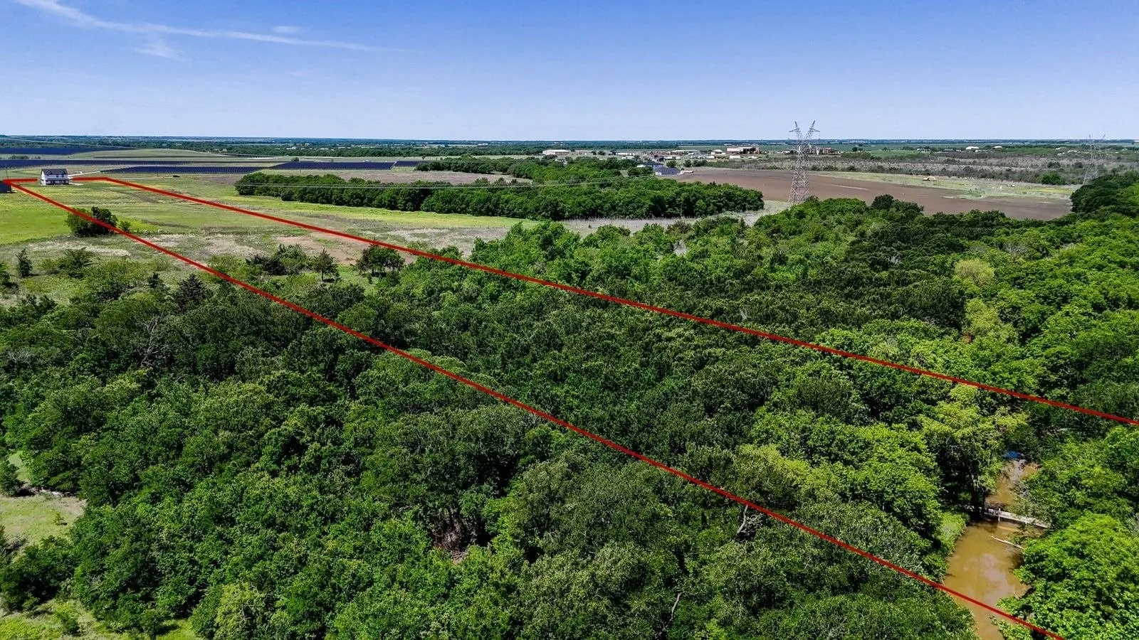 Expansive acreage featuring dense tree cover and open grassy areas