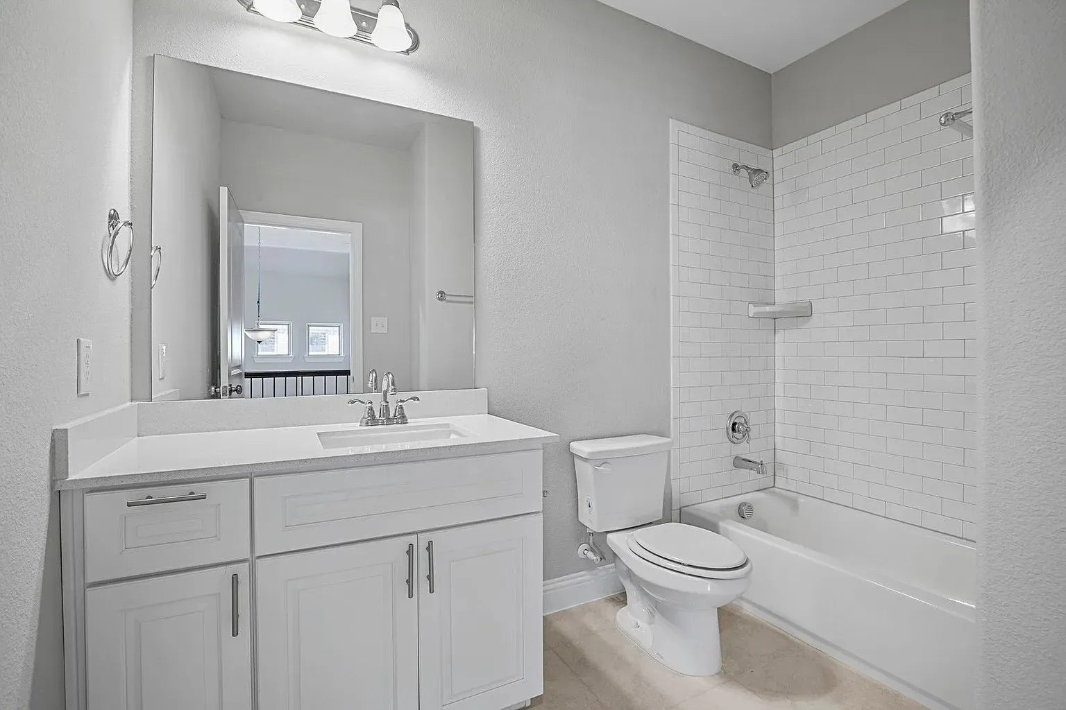 Bathroom featuring a white vanity with a light-toned countertop, an undermount sink with chrome fixtures, and a large wall mirror