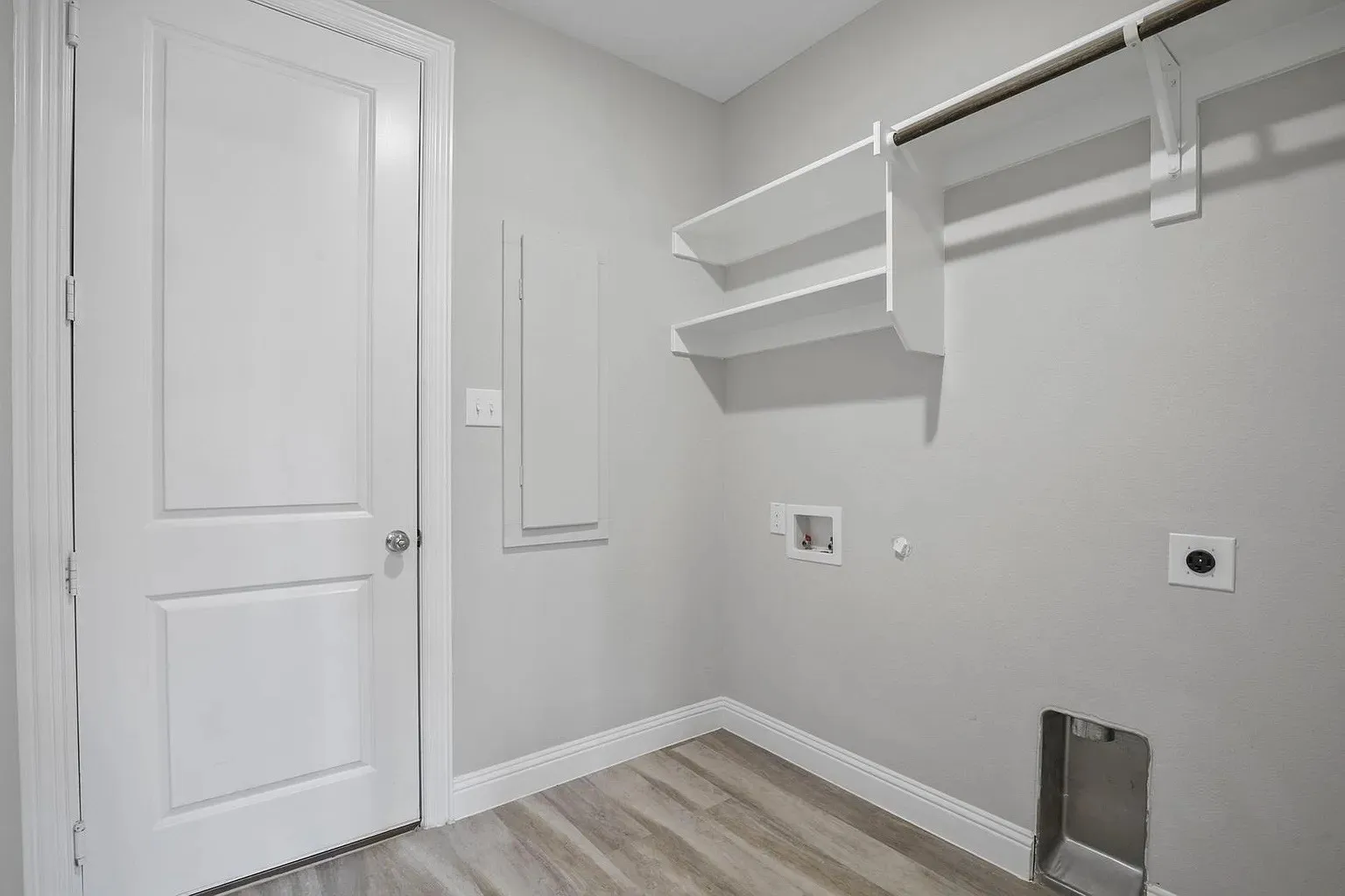 Dedicated utility space featuring wood-finish flooring and light gray wall paint