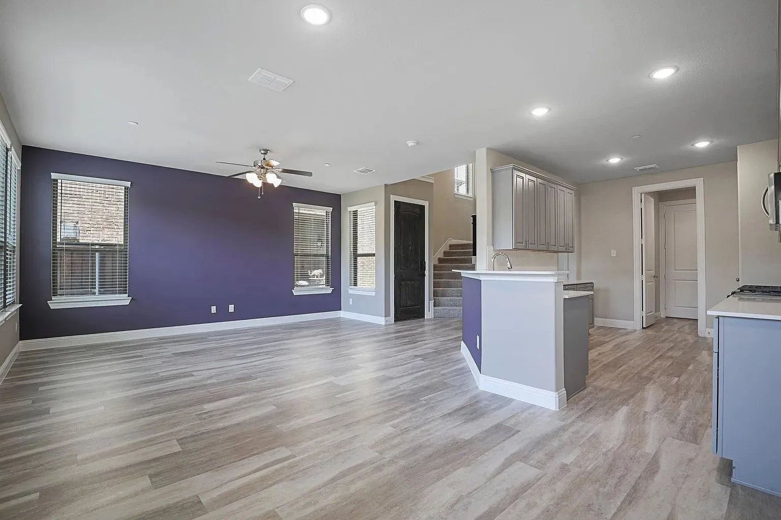 Open-concept living space featuring wood-finish flooring, recessed lighting, and a ceiling fan