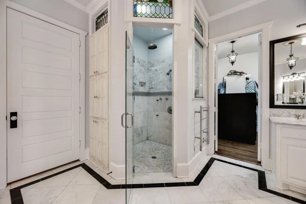 Huge walk in shower with transom windows that match the stain glass