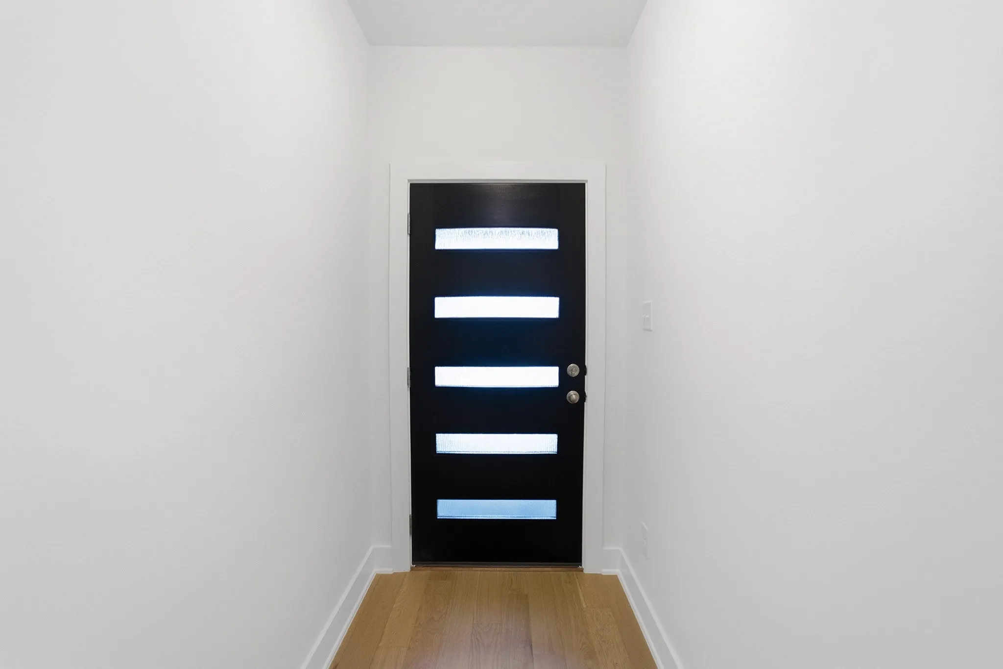 Contemporary entry door with five horizontal lites and a black finish