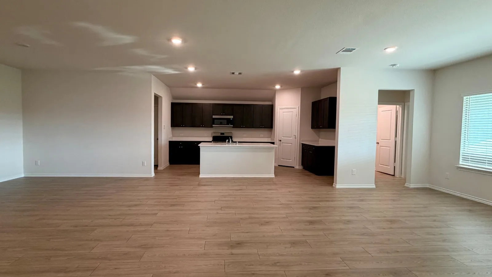 Open-concept living space featuring wood-finish flooring and recessed lighting