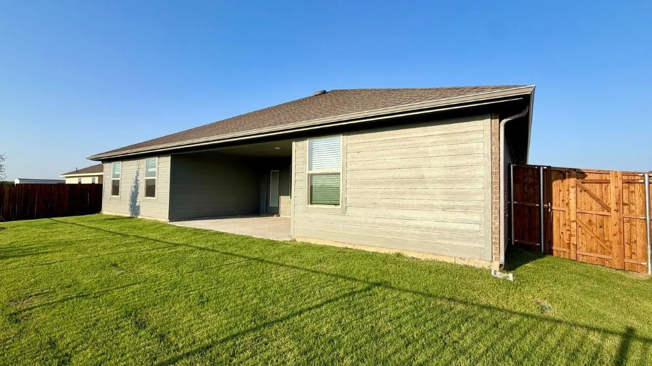 Expansive backyard featuring a manicured lawn and a privacy fence