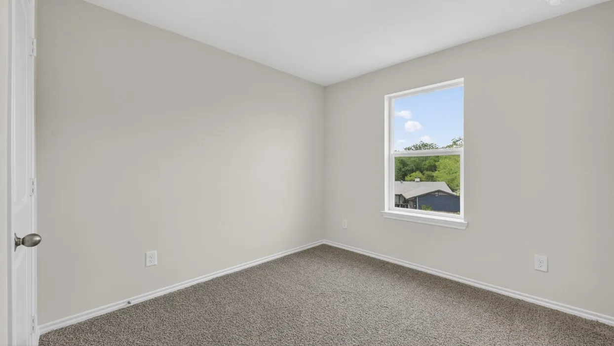 Carpeted interior room with light neutral walls and white trim