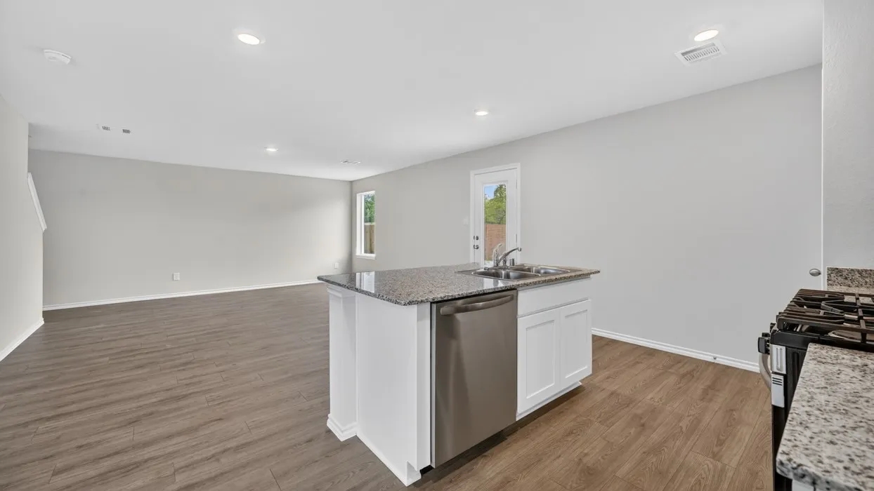 Open-concept kitchen and living area featuring wood-finish flooring, recessed lighting, and light-toned walls