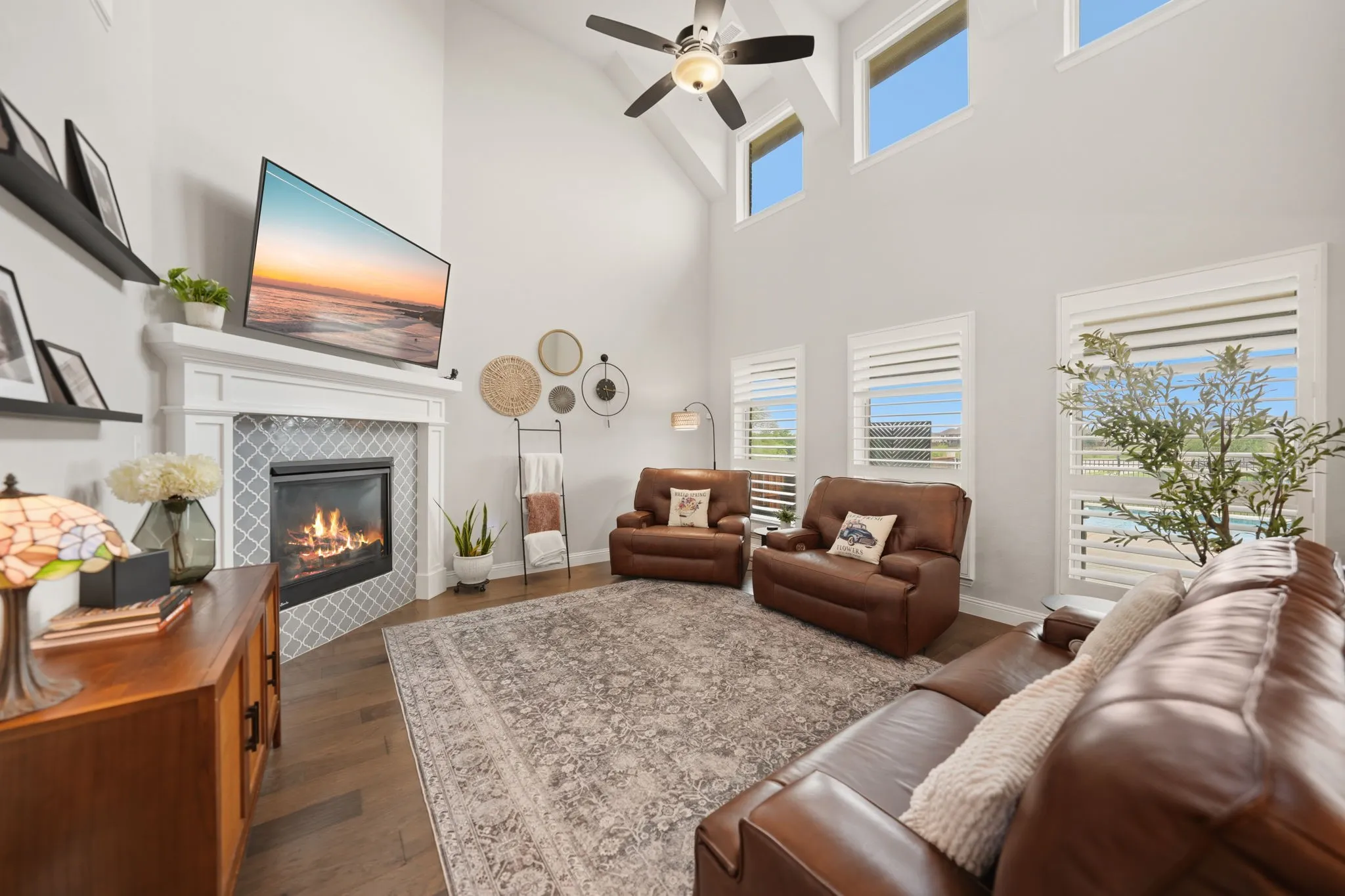 look at all these windows bringing in natural light and the living room overlooks the backyard oasis with extended patio, sparkling pool, and grassy play area