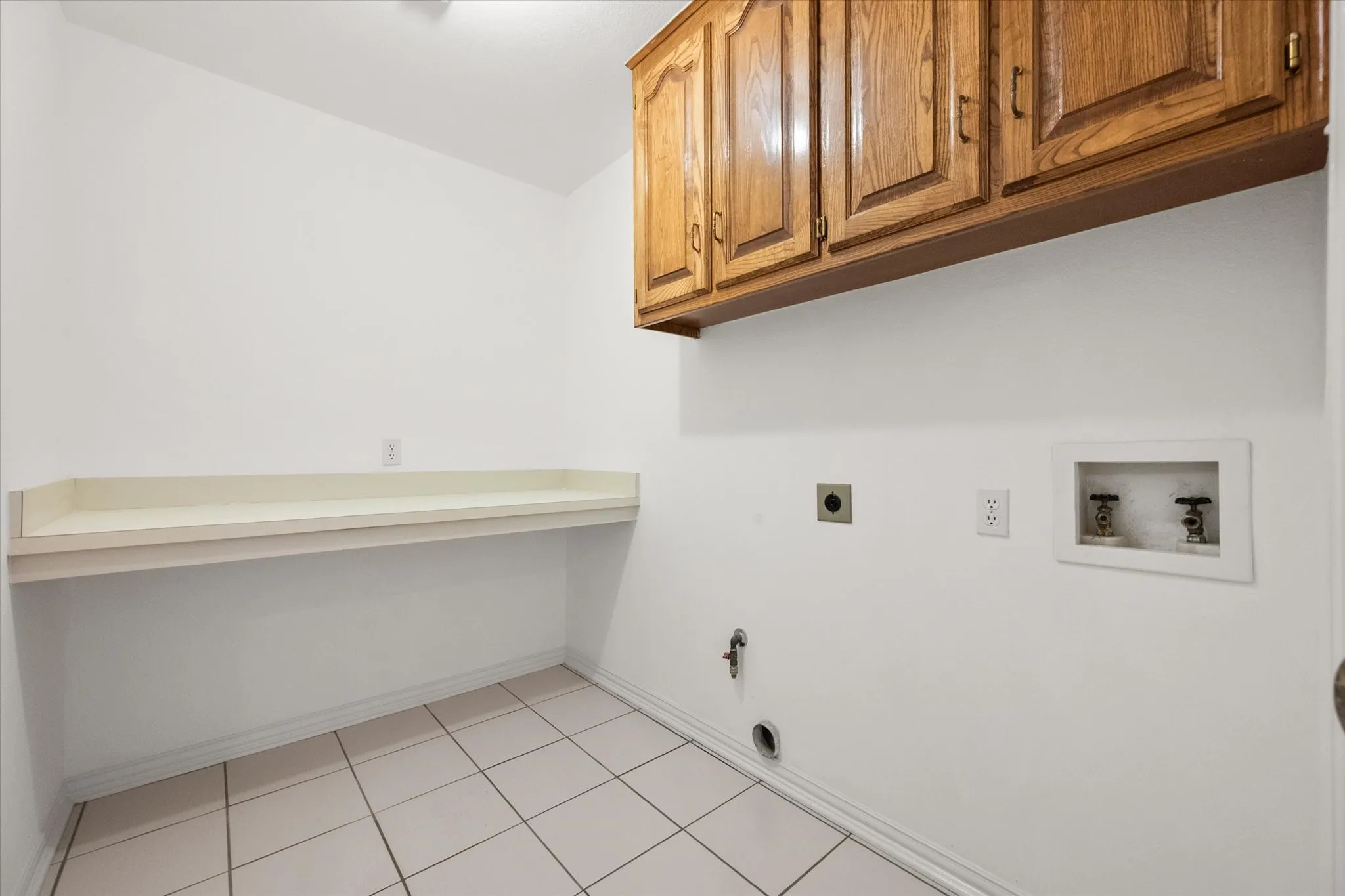Laundry room with built-in cabinetry and folding area