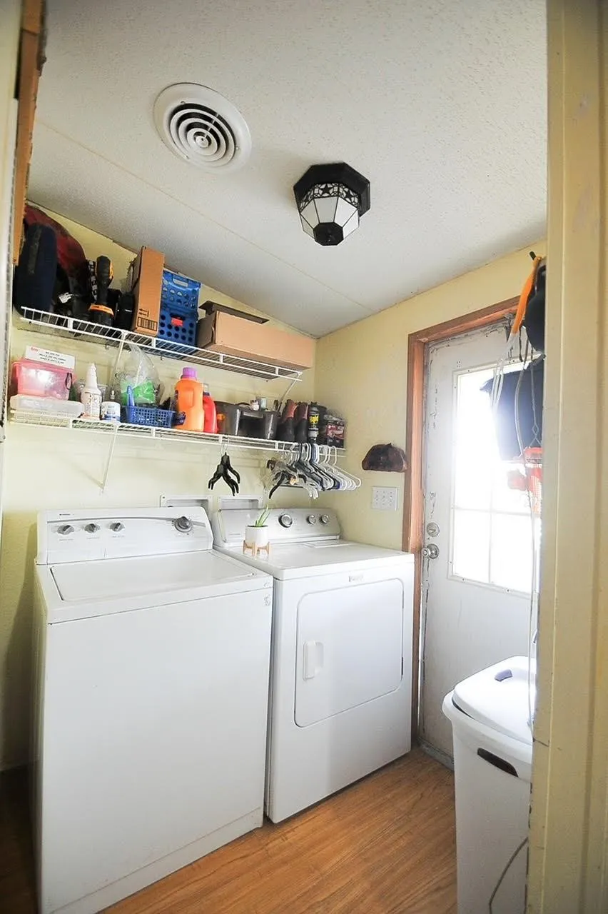 Dedicated laundry area featuring wood-finish flooring and a white exterior door with window