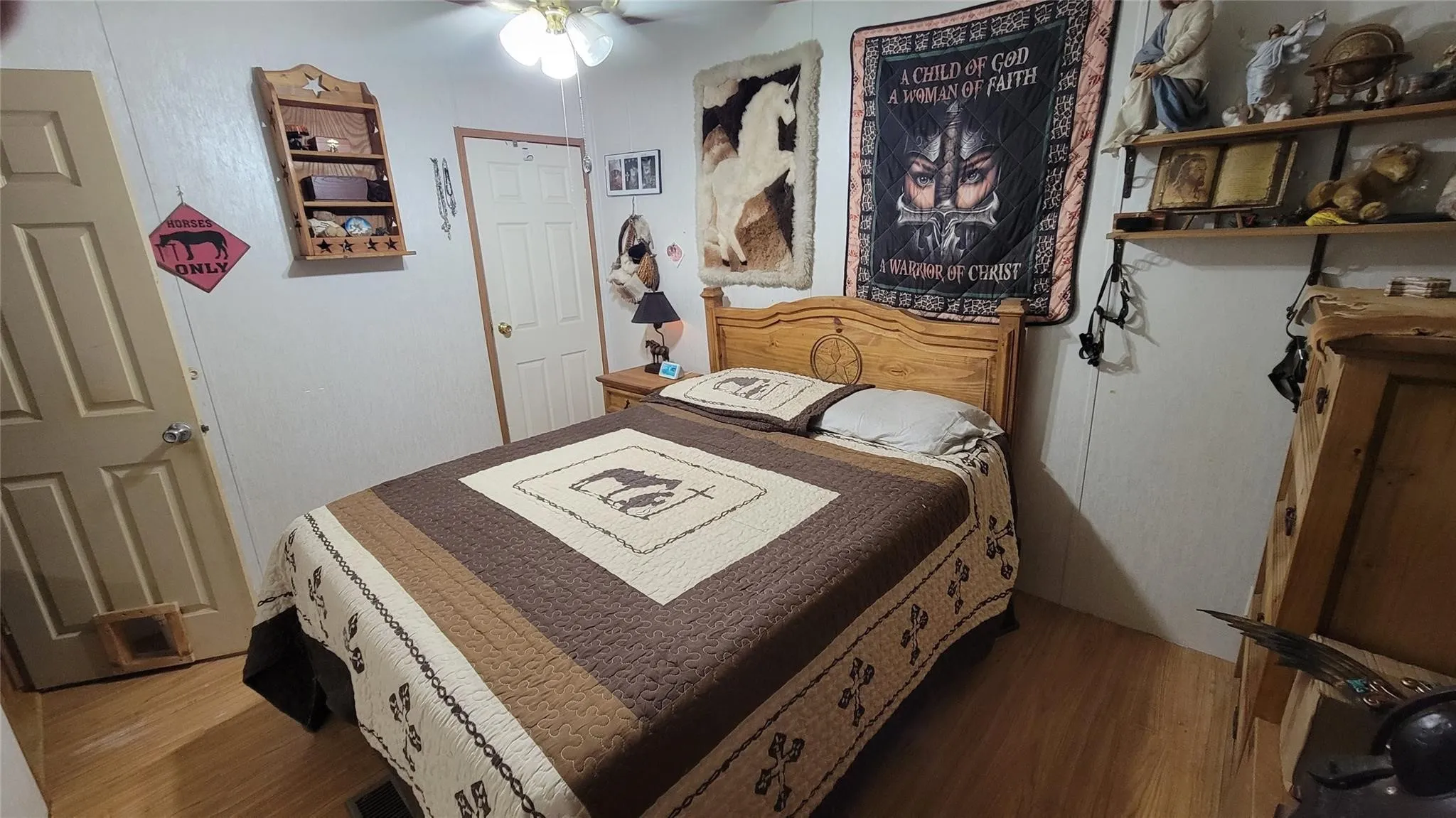 Bedroom featuring wood-finish flooring, a ceiling fan with integrated lighting, and multiple doors