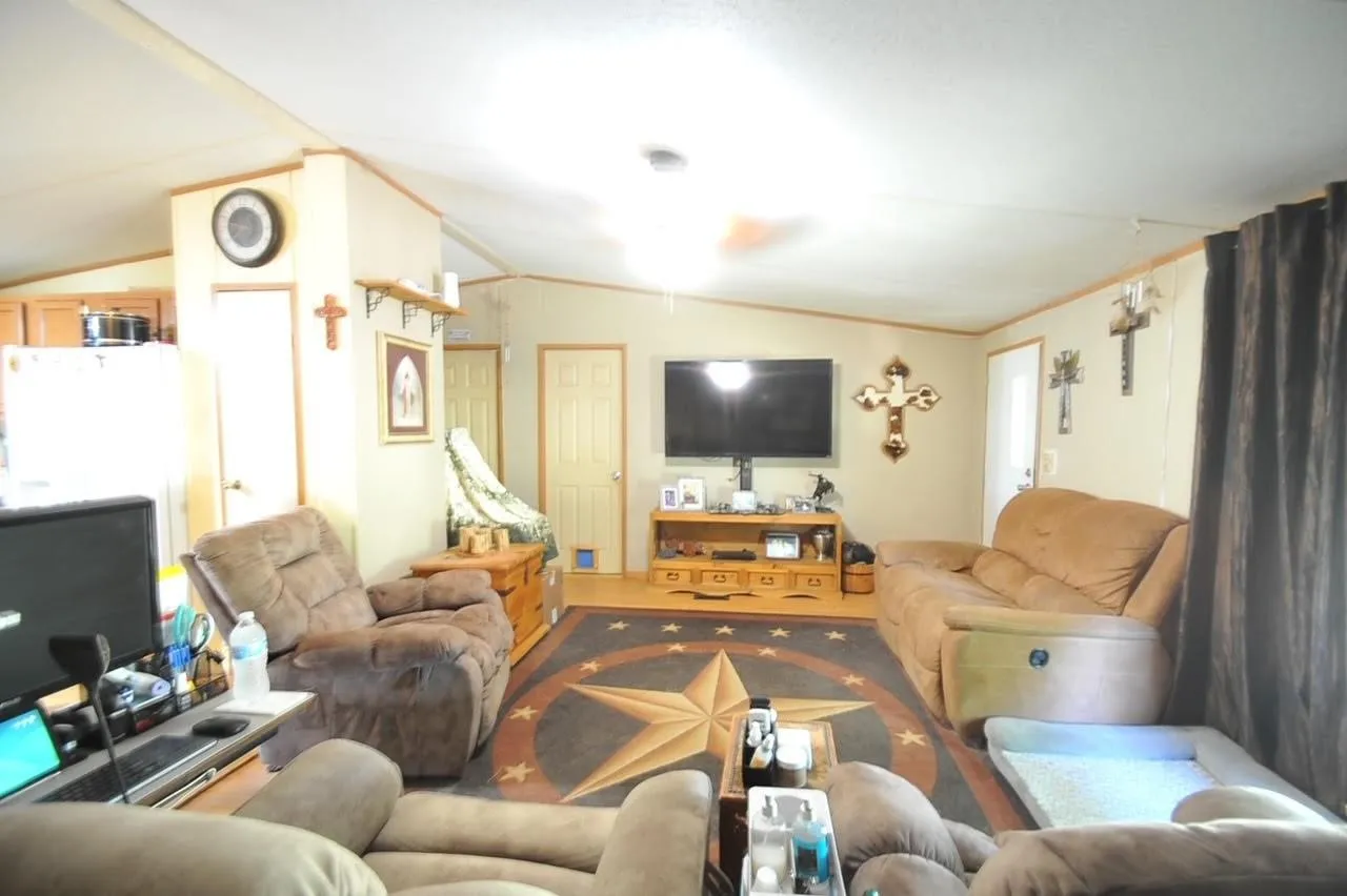 Open-concept living area with light-toned walls and wood-finish flooring