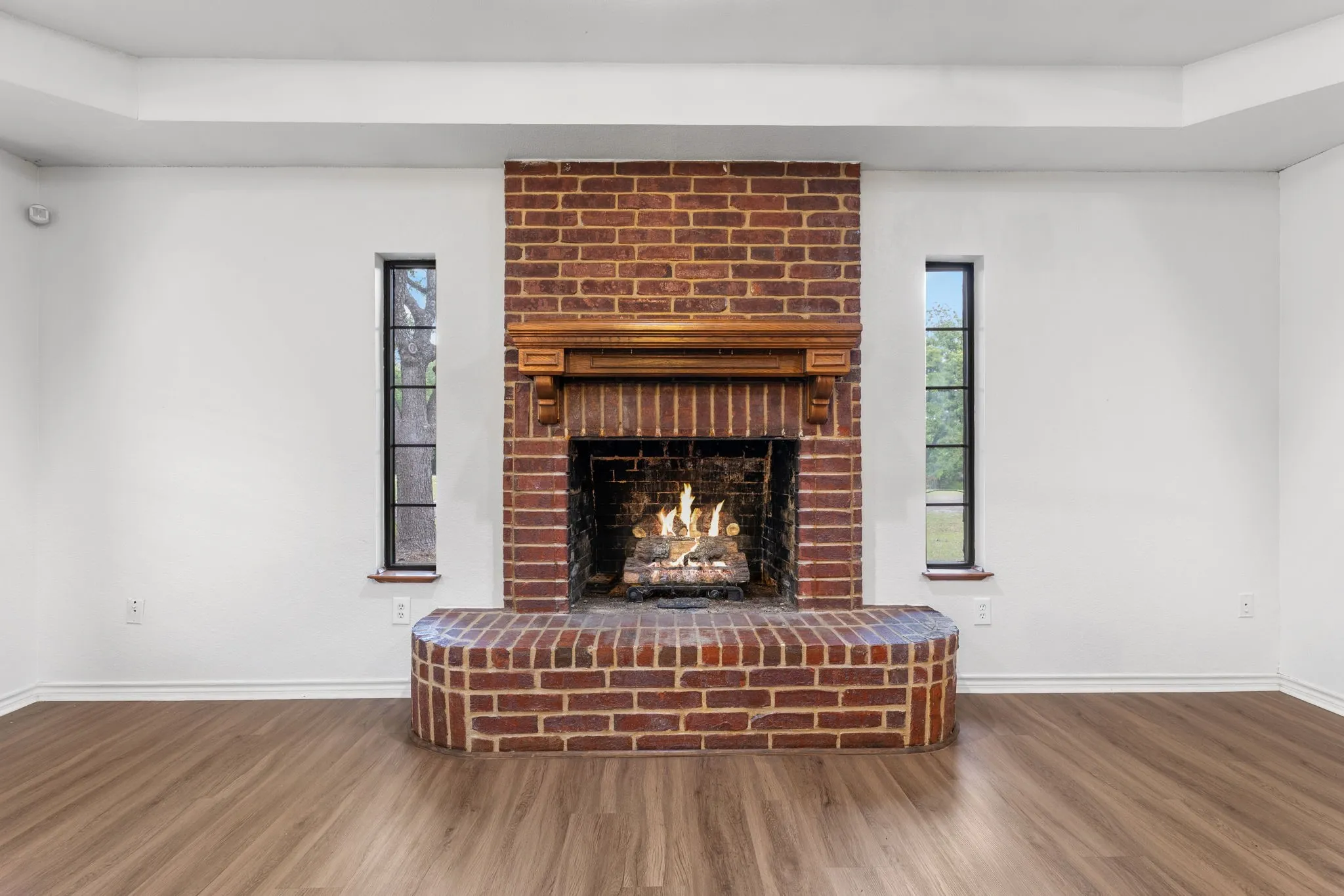 Brick fireplace with a substantial hearth and wood mantelpiece