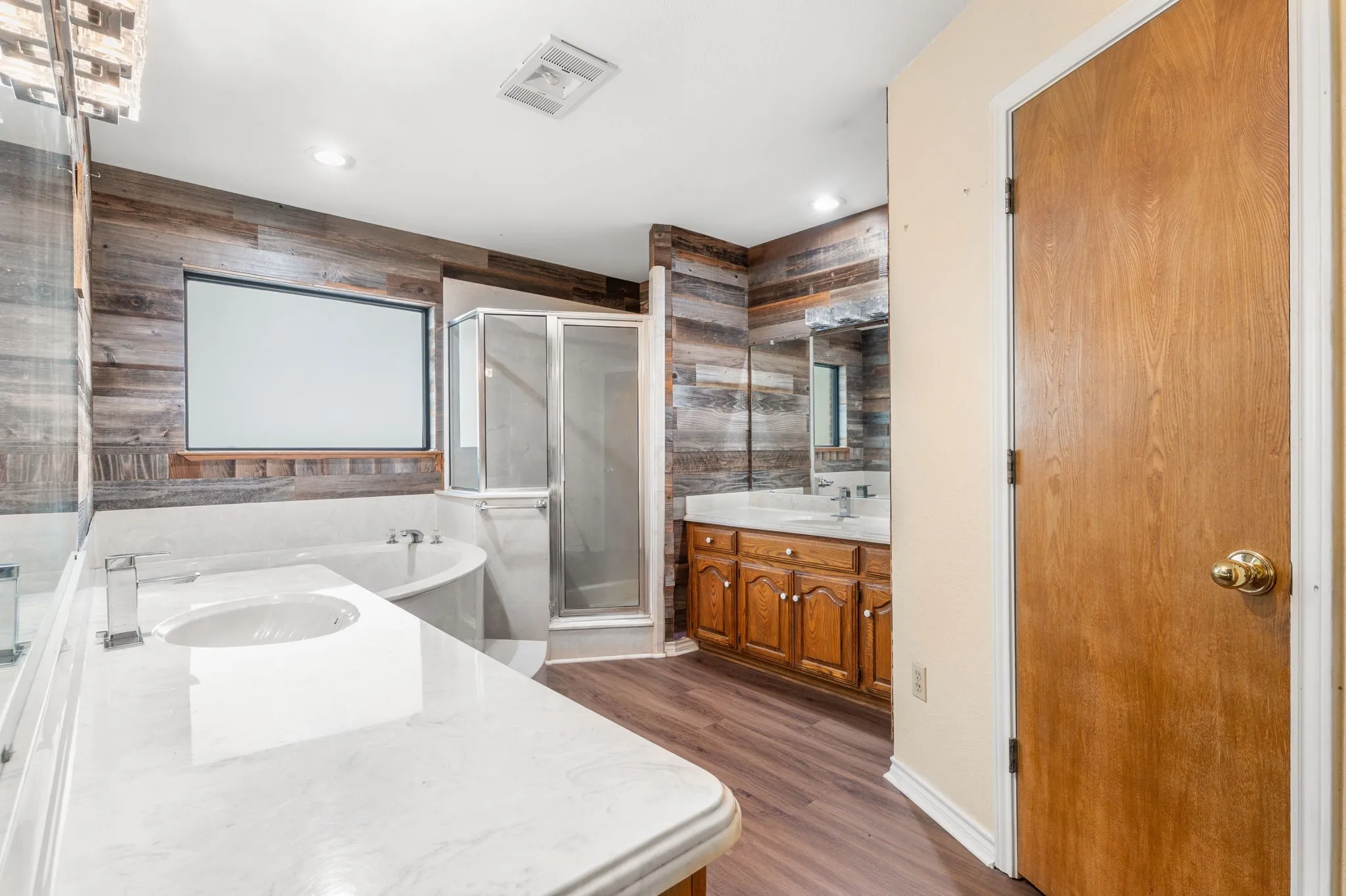 Bathroom featuring wood-finish flooring and shiplap wall accents