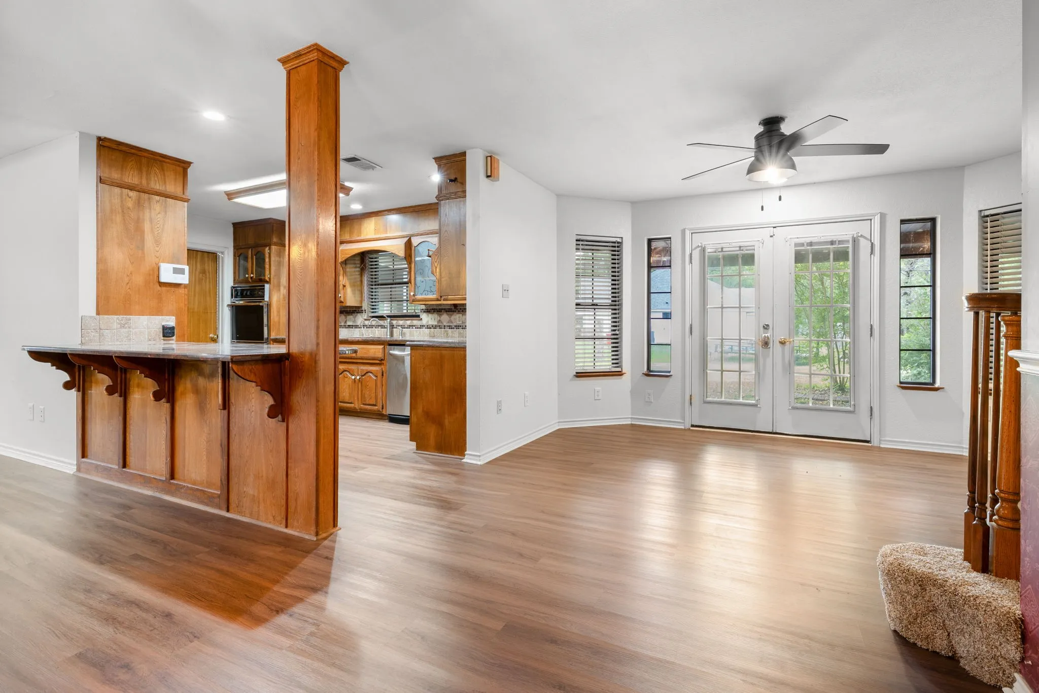 Open concept living area featuring wood-finish flooring and white walls