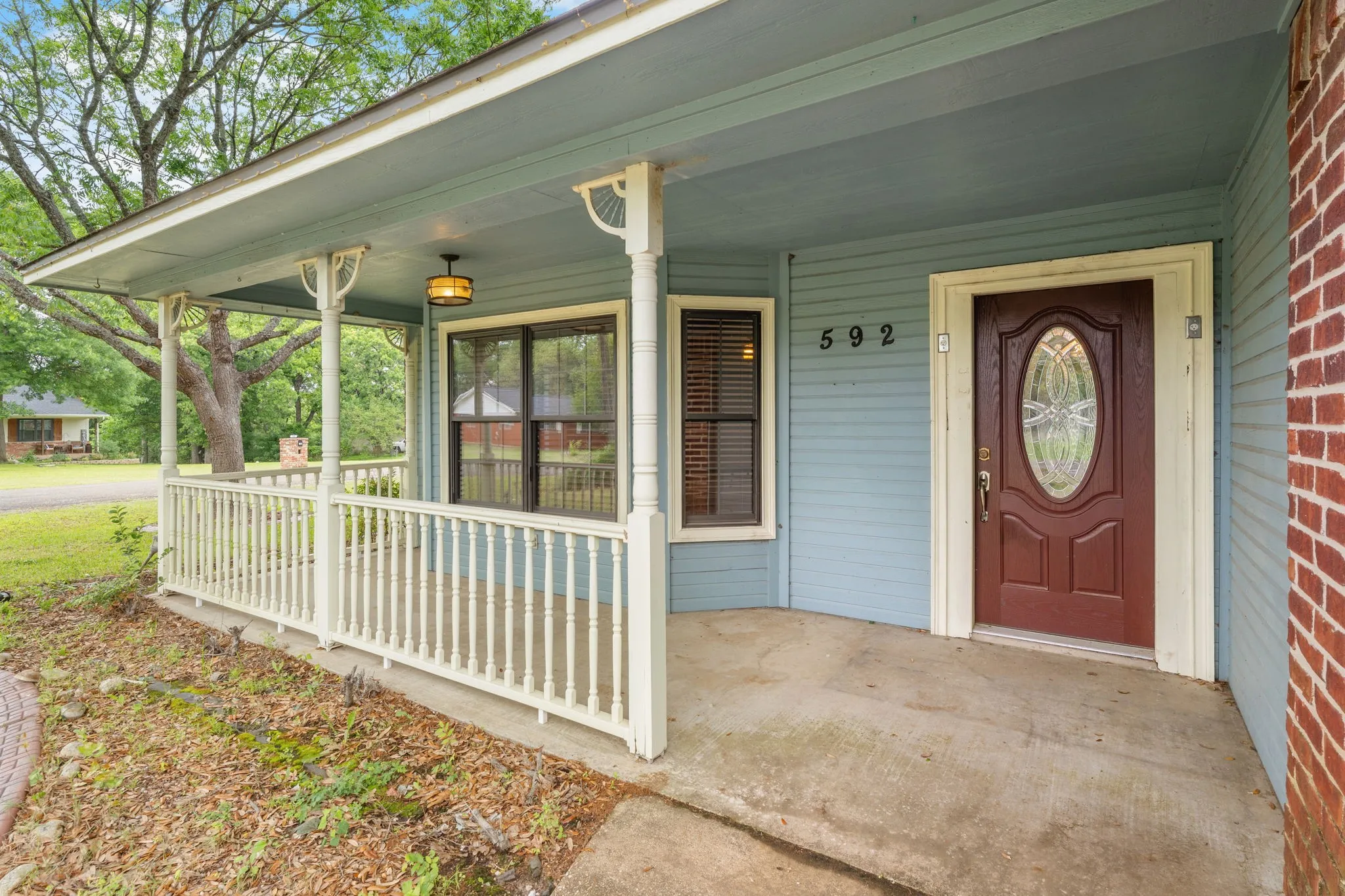 Covered front porch with white balusters and columns
