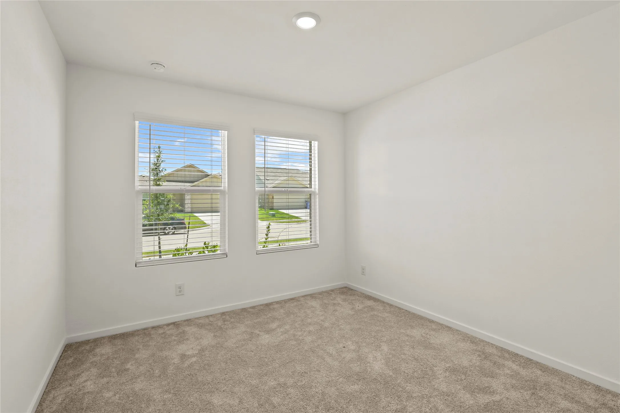 Bedroom with two windows featuring horizontal blinds