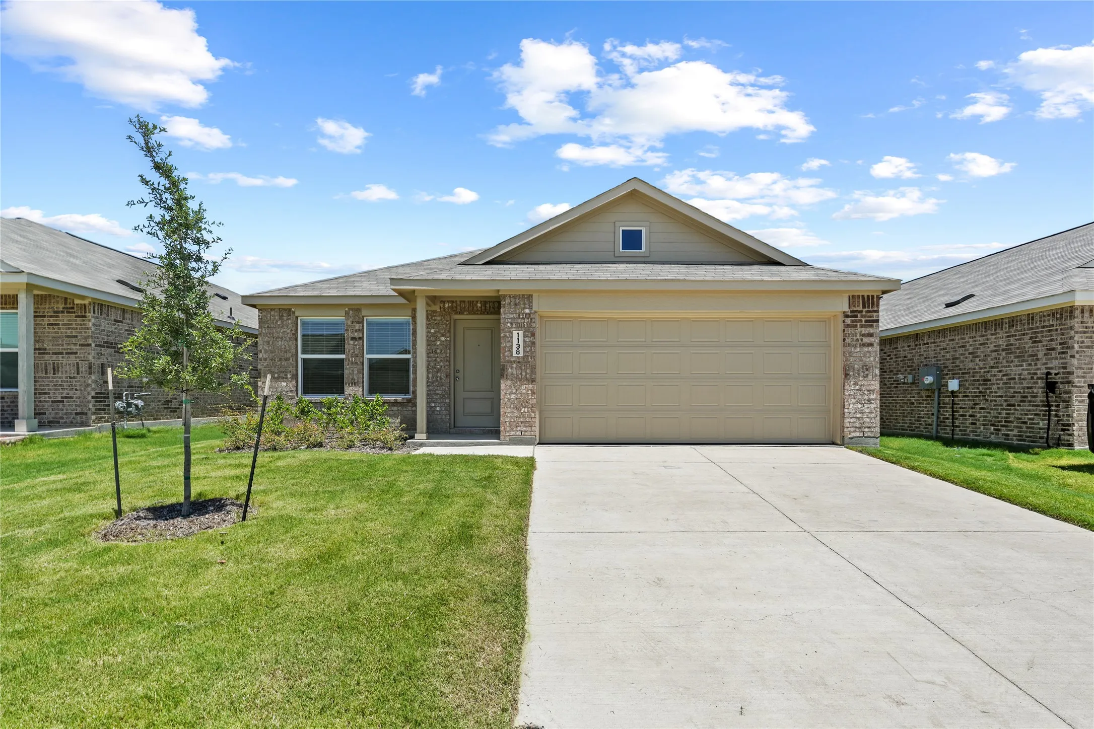 Single-story residence featuring a brick and siding exterior, an attached two-car garage, and a concrete driveway