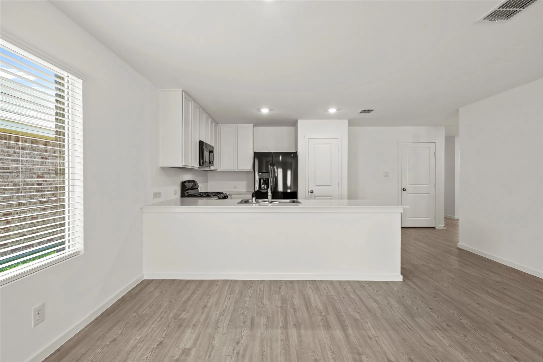 Open-concept living space with wood-finish flooring