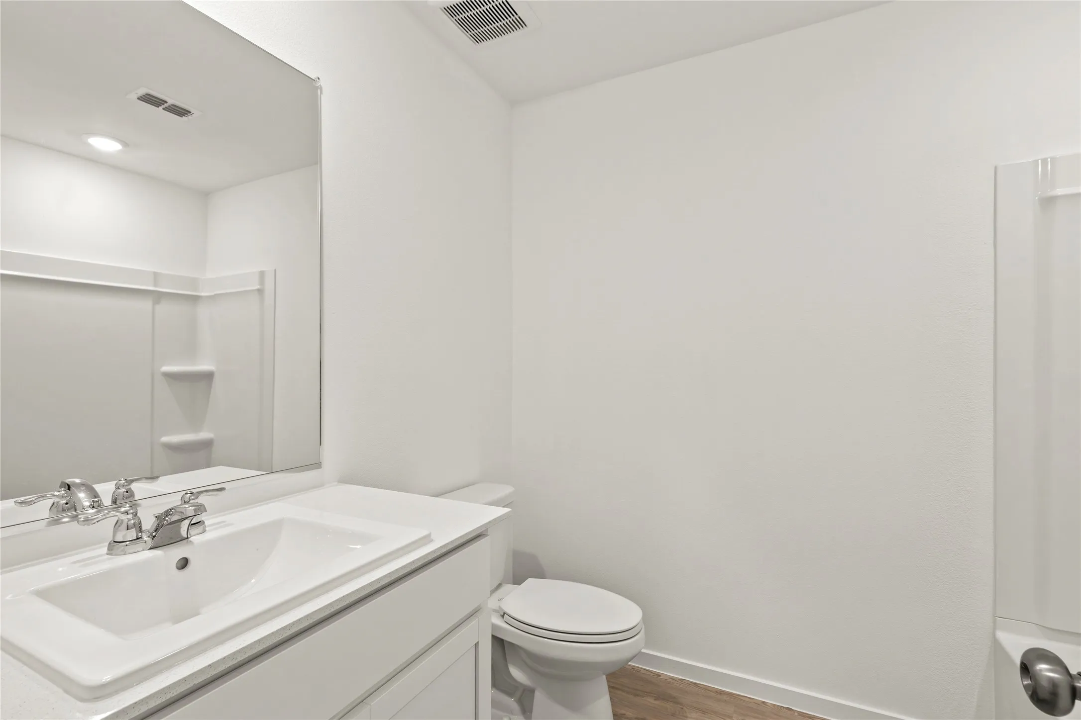Modern bathroom vanity with integrated sink, chrome faucet, and expansive wall mirror