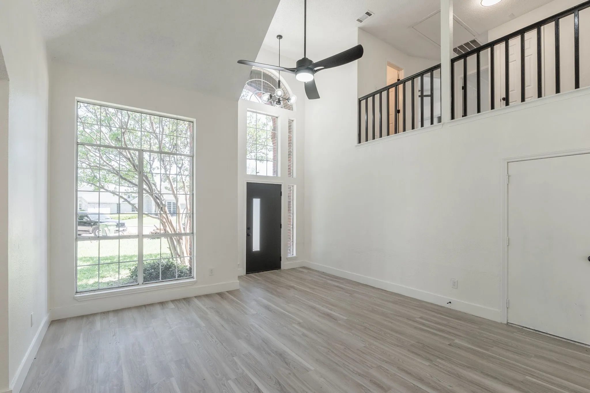 Two-story living area featuring high ceilings and wood-finish flooring
