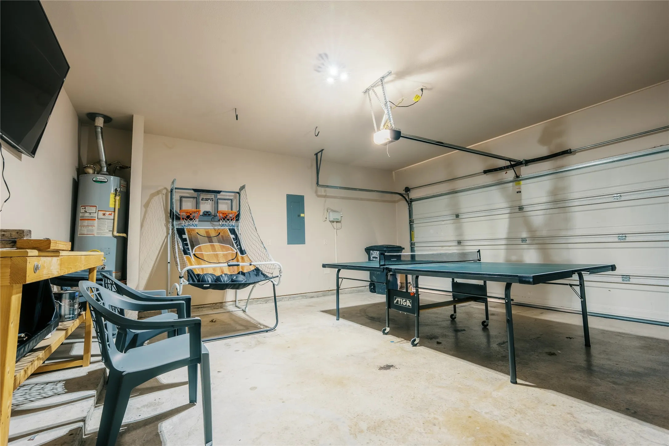 Attached garage space featuring a concrete floor, overhead lighting, and an automatic garage door opener