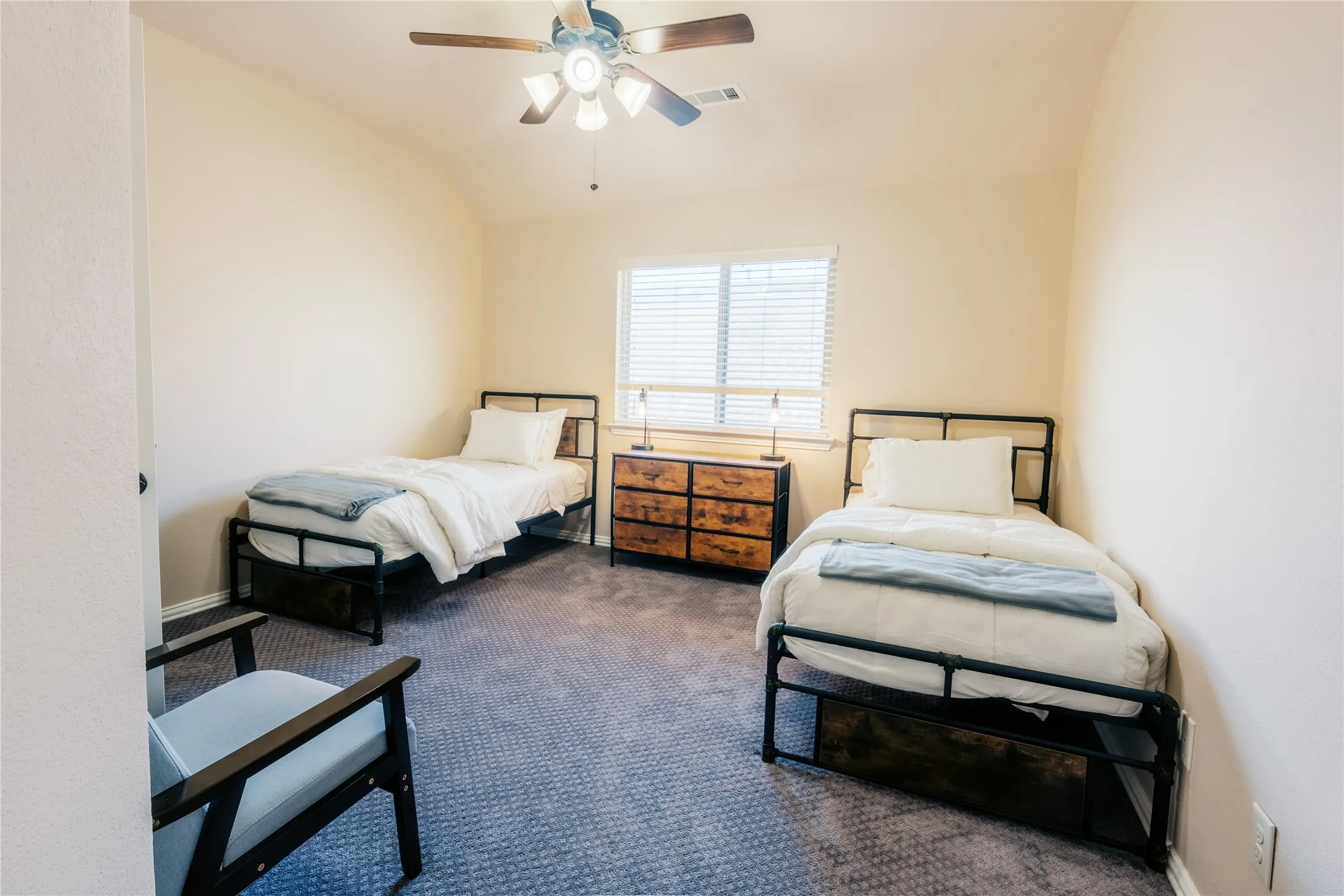 Carpeted room with a ceiling fan