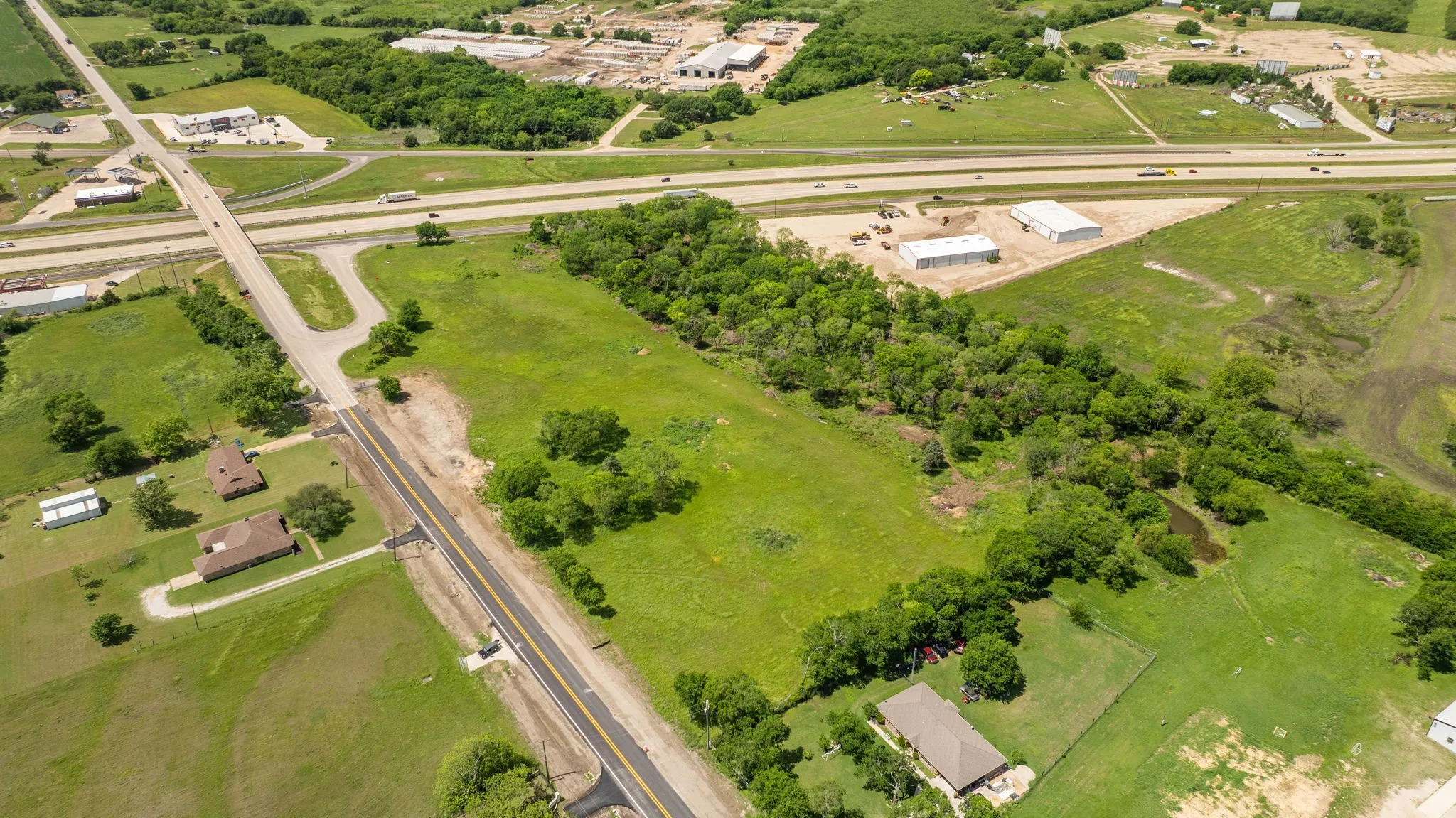 Expansive acreage featuring abundant natural tree coverage, open grassy areas, and a visible pond