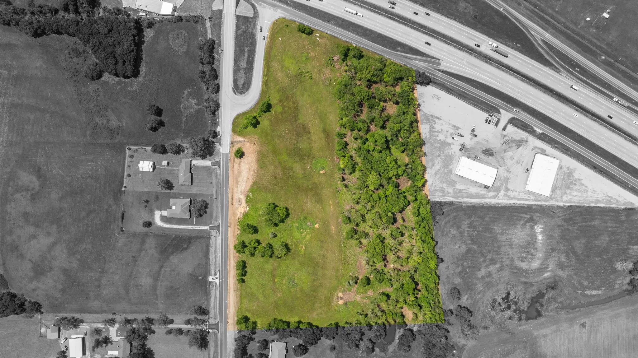 Expansive land parcel featuring a mix of open grassy areas and mature tree coverage