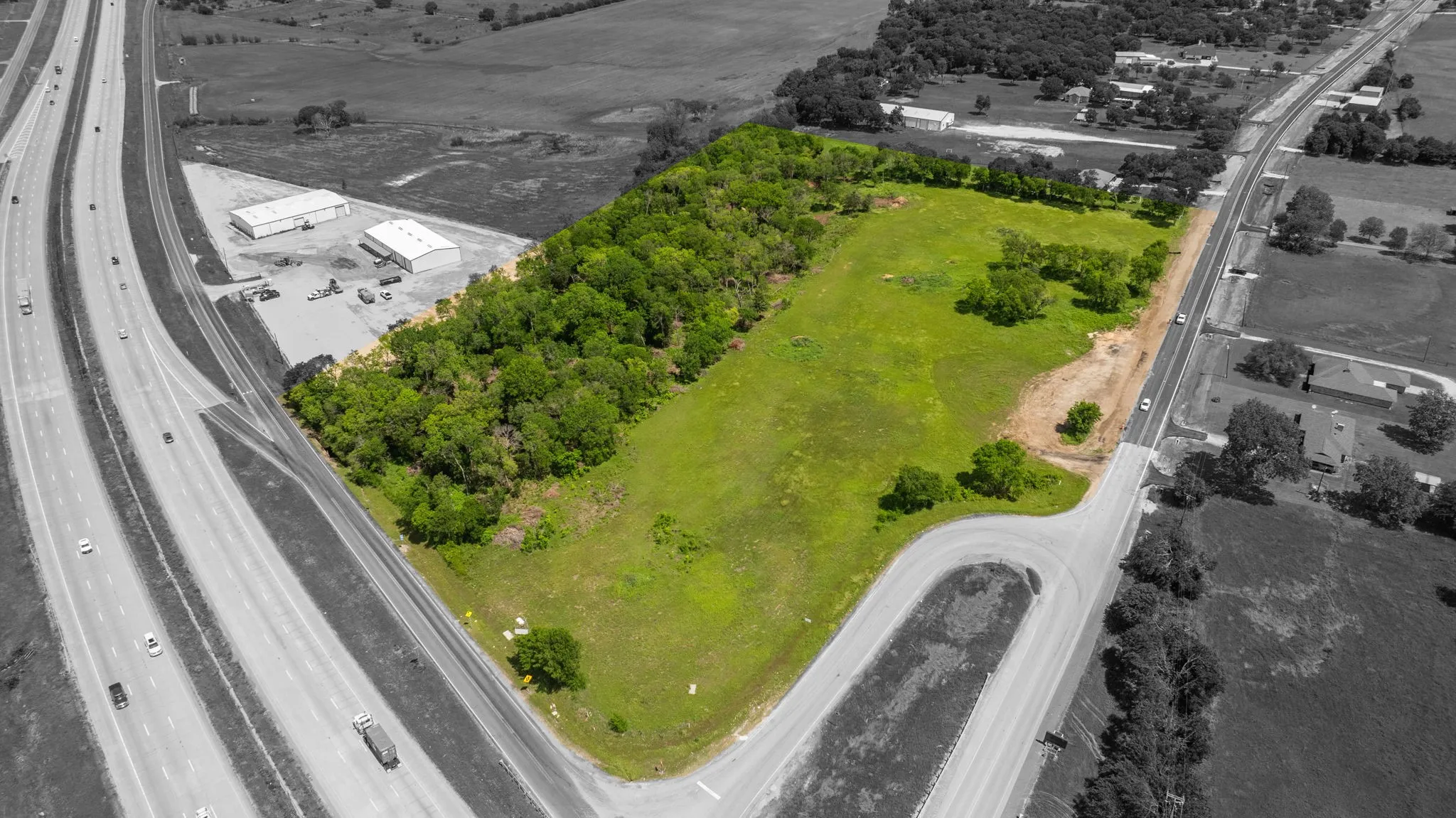 Expansive land parcel featuring a mix of cleared green space and mature tree lines