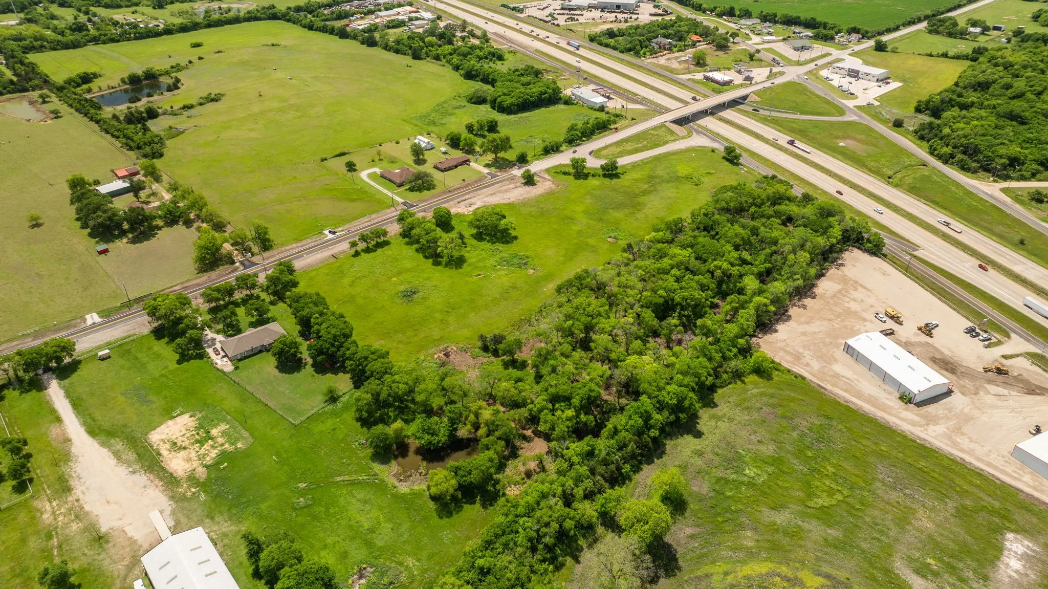 Expansive acreage featuring mature trees, open fields, and highway proximity